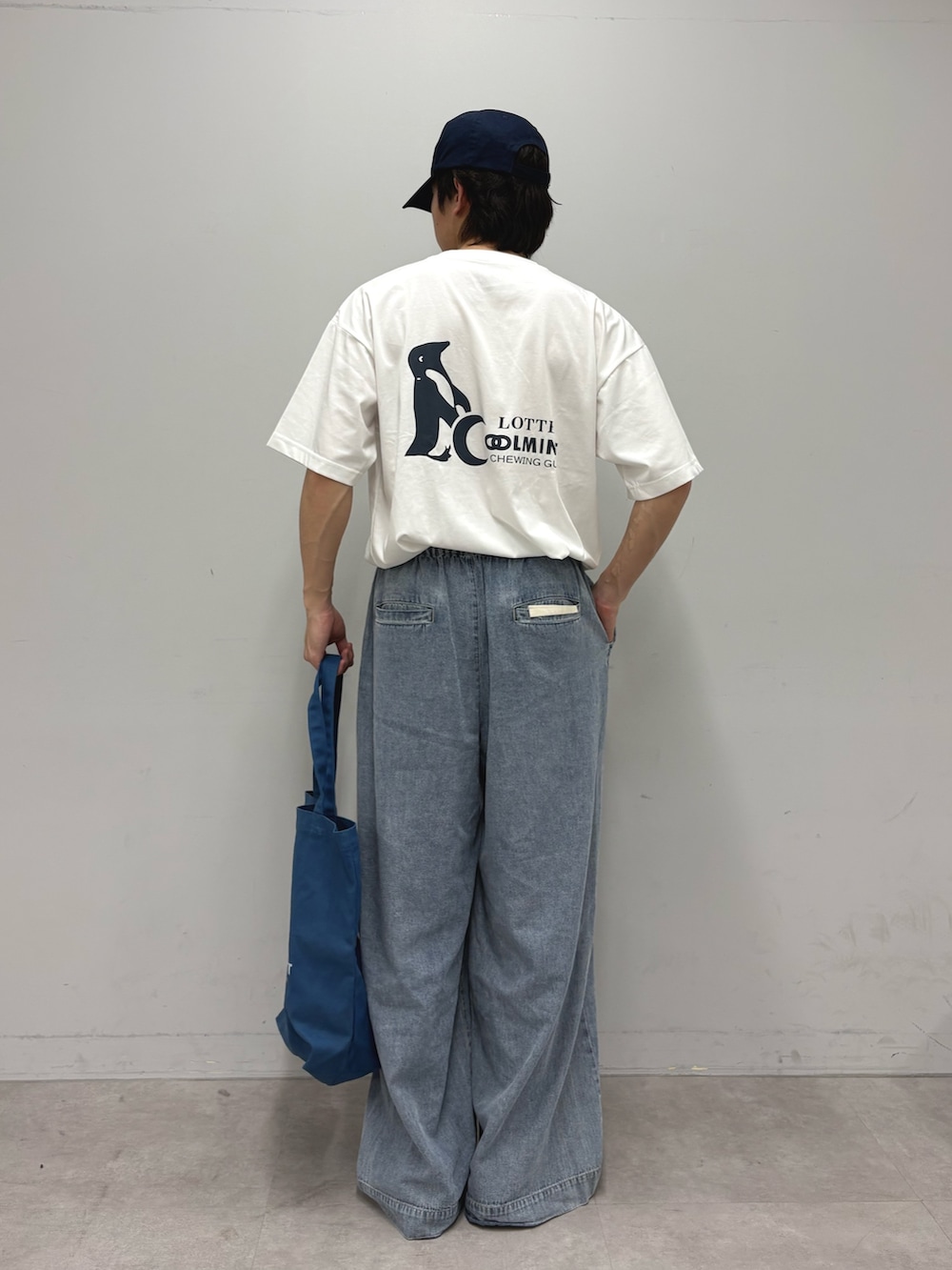 ホワイト系のTシャツ/カットソー、ブルー系のデニムパンツ、ブルー系のトートバッグを着用したメンズの春コーディネートの3枚目の写真