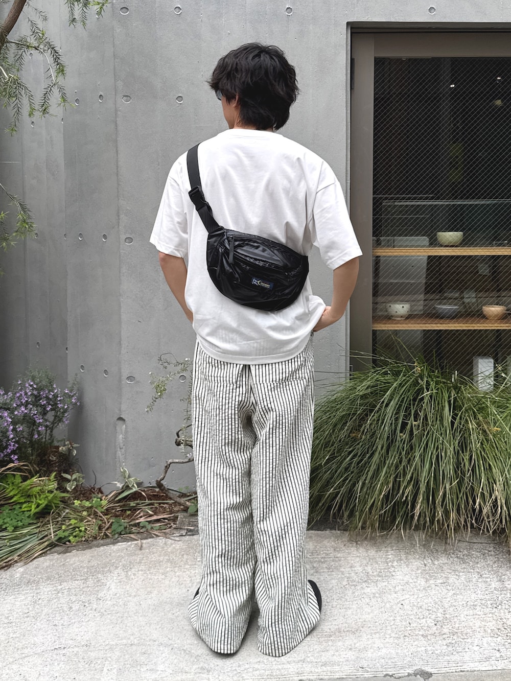 ホワイト系のTシャツ/カットソー、ブラック系のボディバッグ/ウエストポーチ、ホワイト系のその他パンツを着用したメンズの春コーディネートの2枚目の写真