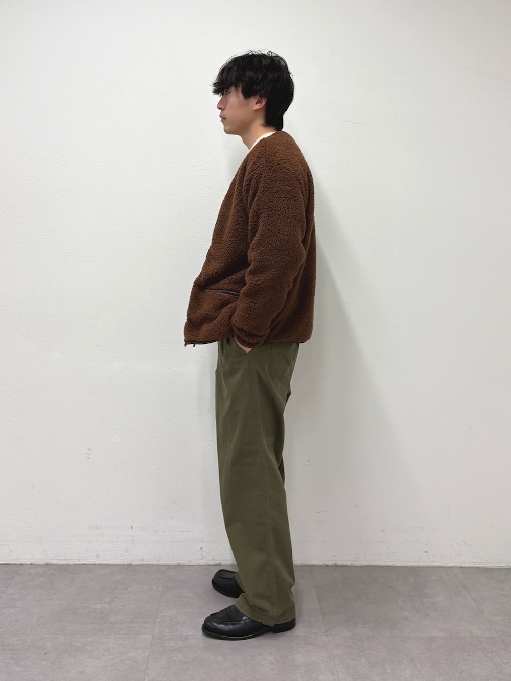 ブラウン系のブルゾン、ホワイト系のニット/セーター、グリーン系のその他パンツを着用したメンズの冬コーディネートの2枚目の写真