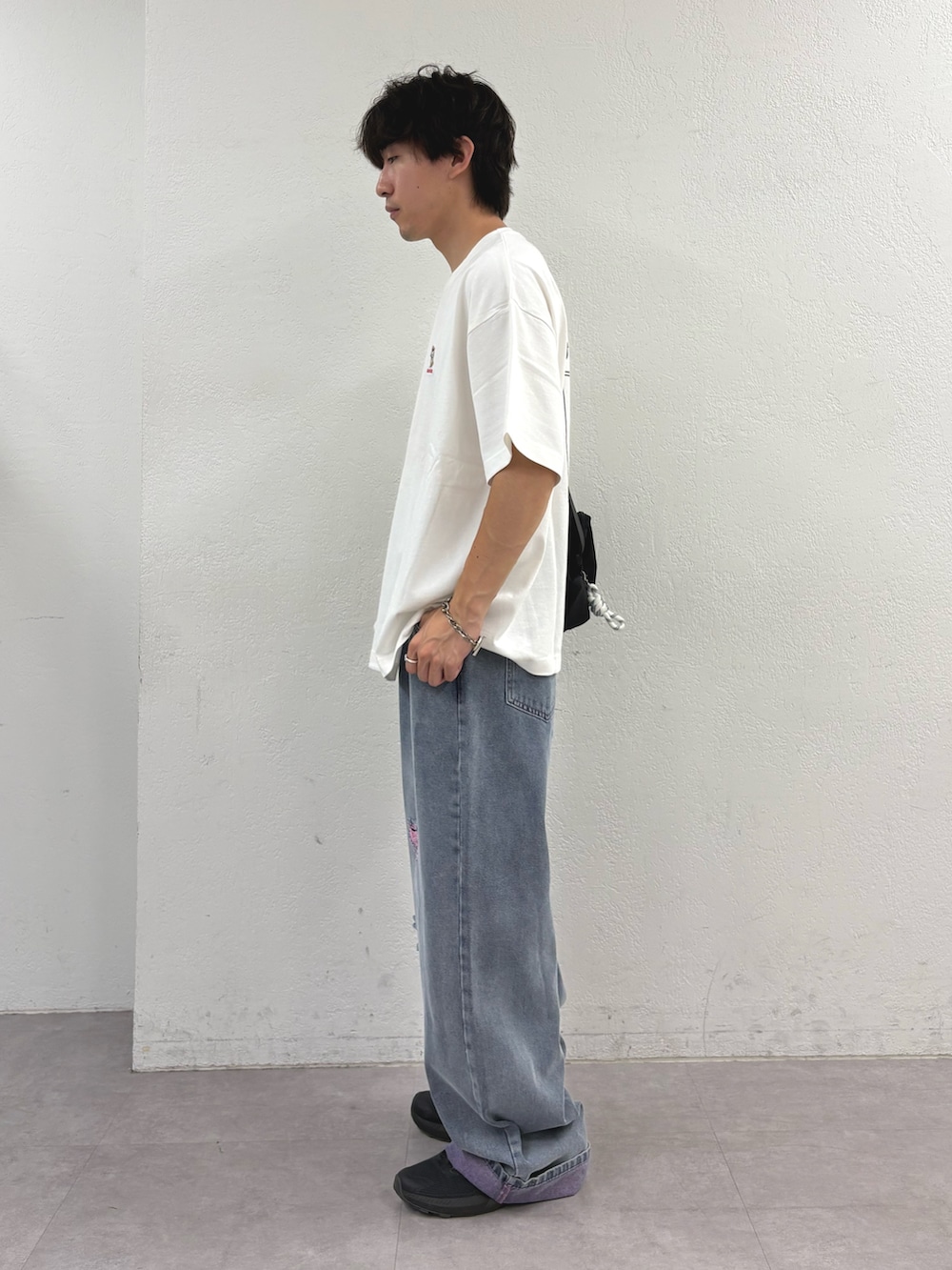 ホワイト系のTシャツ/カットソー、ブラック系のバックパック/リュック、ピンク系のデニムパンツを着用したメンズの夏コーディネートの2枚目の写真