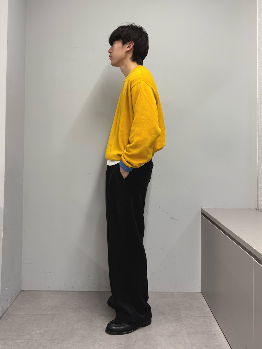 イエロー系のニット/セーター、ブラック系のその他パンツを着用したメンズの冬コーディネートの2枚目の写真