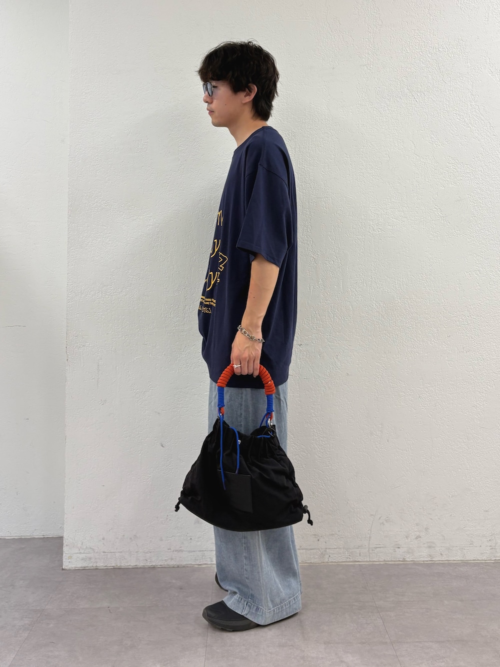 ブルー系のTシャツ/カットソー、ブルー系のデニムパンツ、ブラック系のトートバッグを着用したメンズの夏コーディネートの2枚目の写真