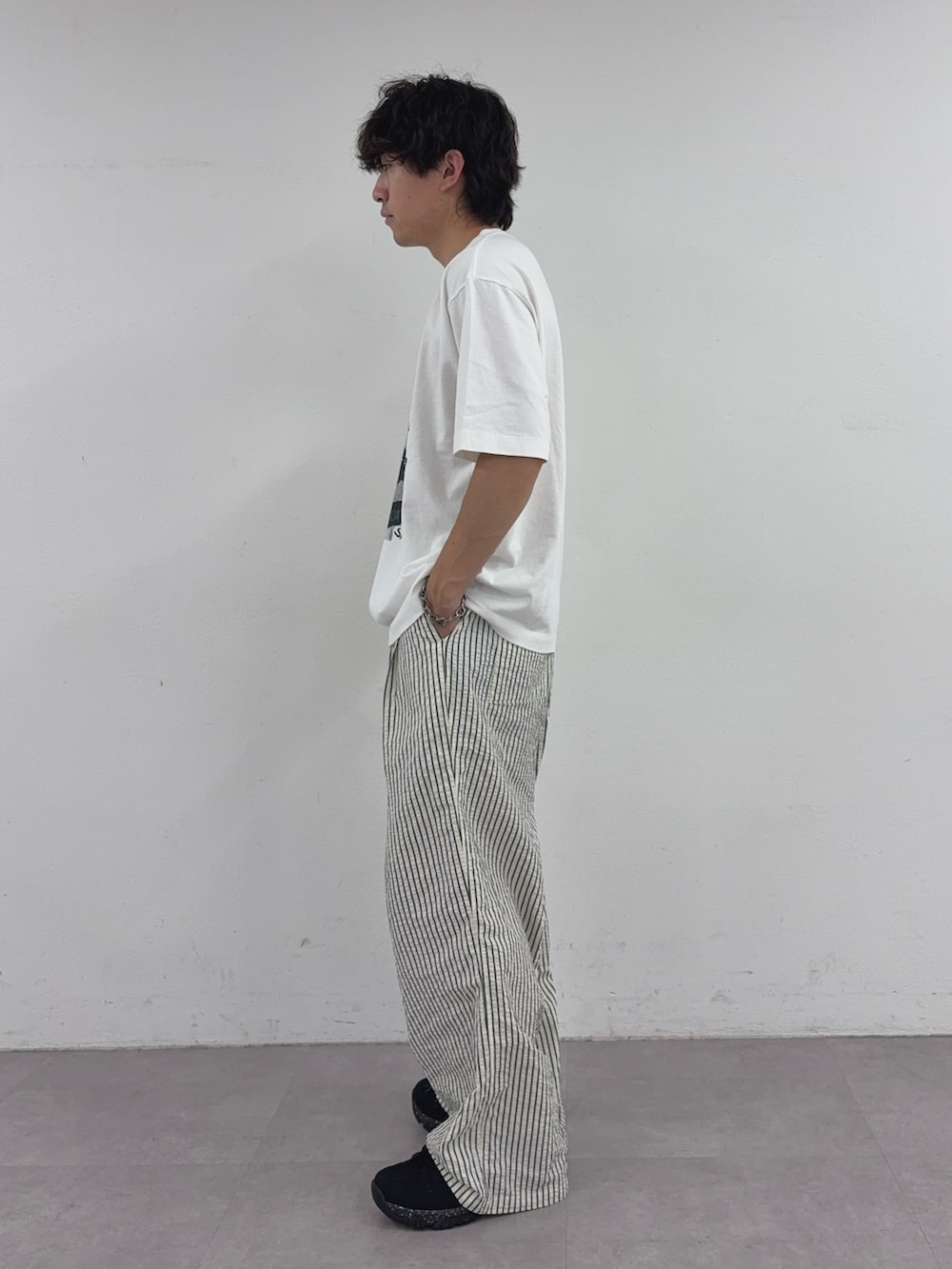 ホワイト系のTシャツ/カットソー、ホワイト系のその他パンツ、ブラック系のスニーカーを着用したメンズの春コーディネートの2枚目の写真