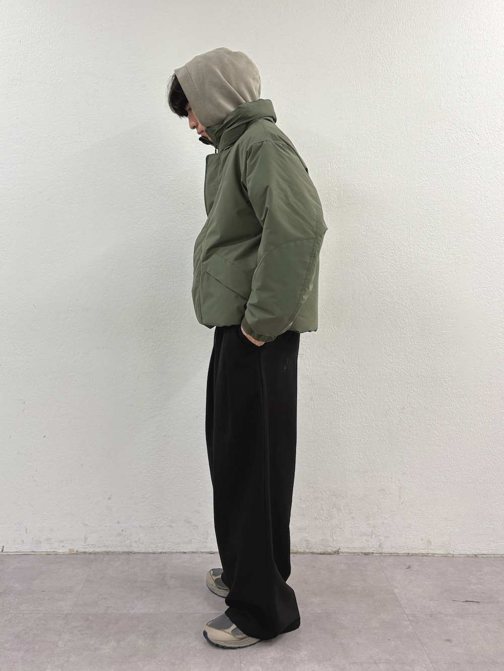 ベージュ系のパーカー、グリーン系のダウンジャケット/コート、ブラック系のその他パンツを着用したメンズの冬コーディネートの2枚目の写真