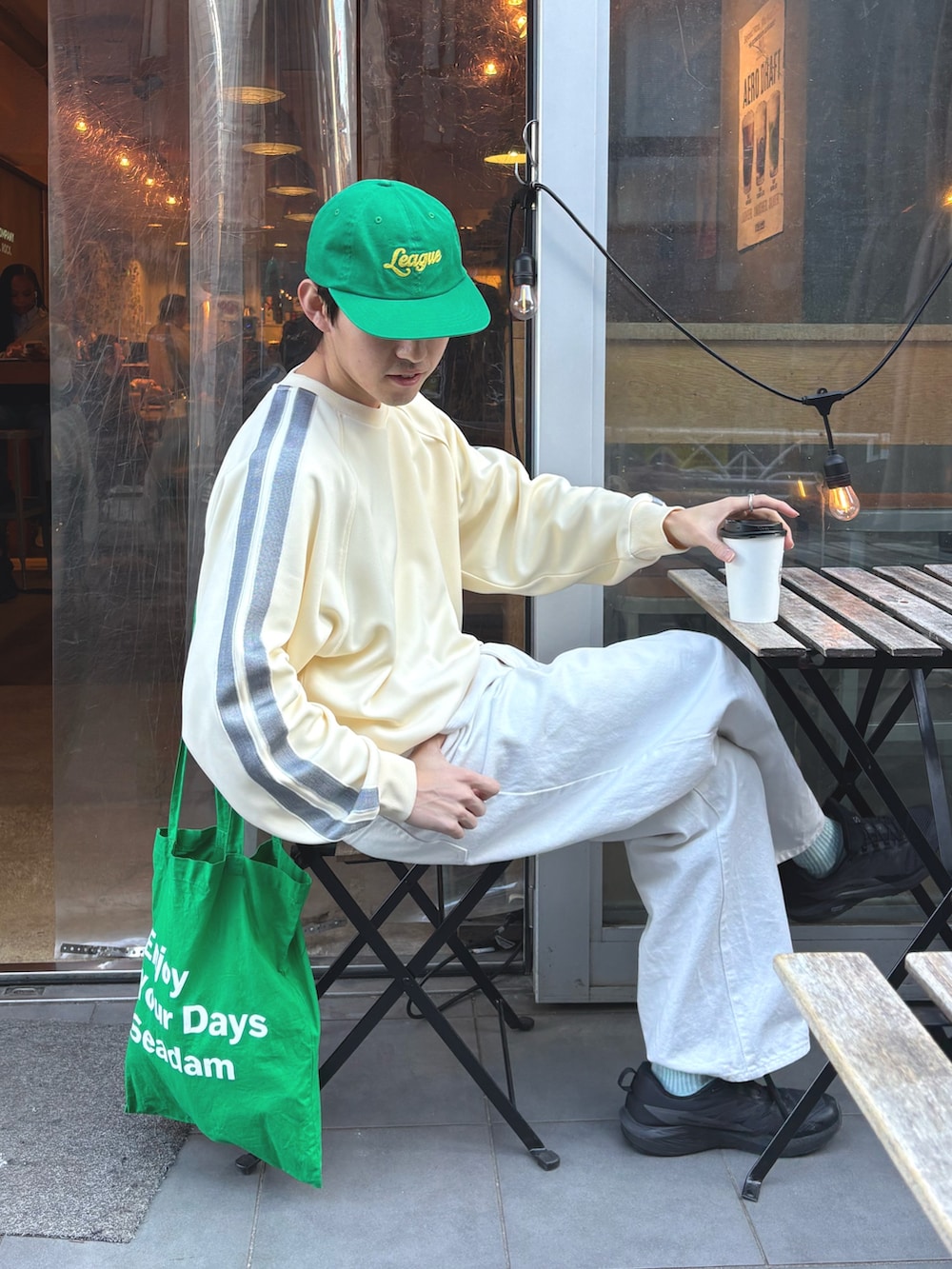 ホワイト系のスウェット、グリーン系のキャップを着用したメンズの冬コーディネートの2枚目の写真