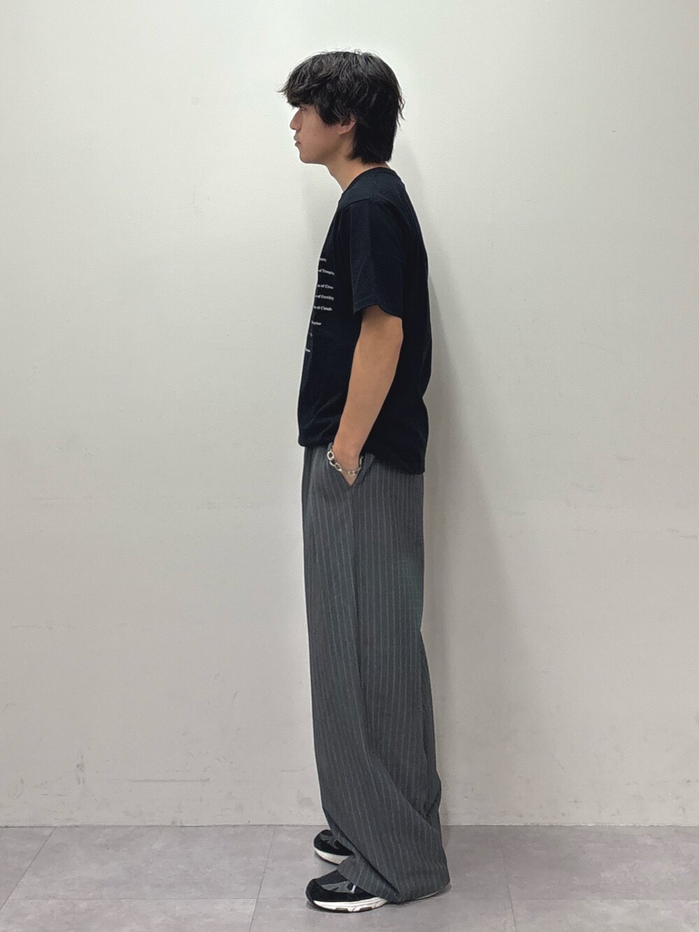 ブラック系のTシャツ/カットソー、グレー系のスラックスを着用したメンズの夏コーディネートの2枚目の写真