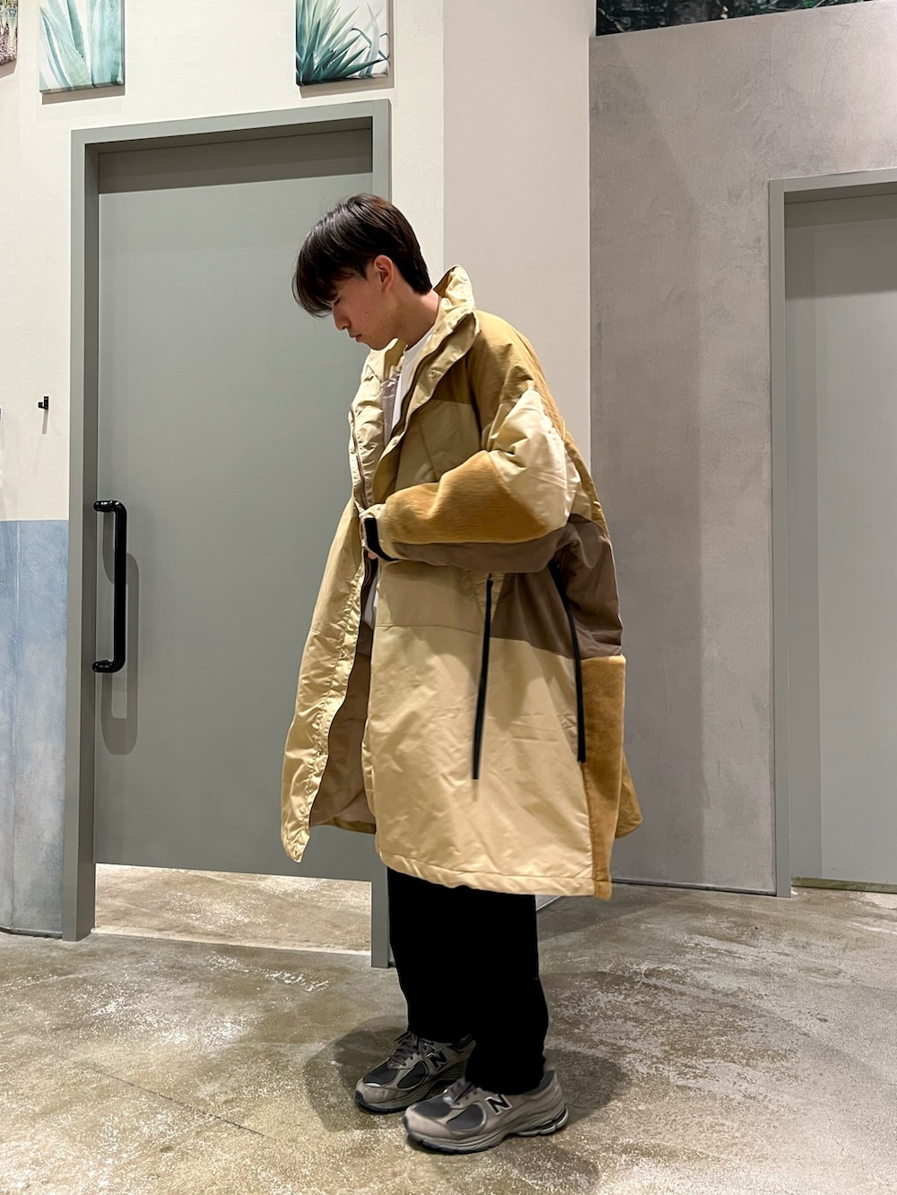 グレー系のスニーカー、ホワイト系のスウェット、イエロー系のダウンジャケット/コートを着用したメンズの冬コーディネートの3枚目の写真