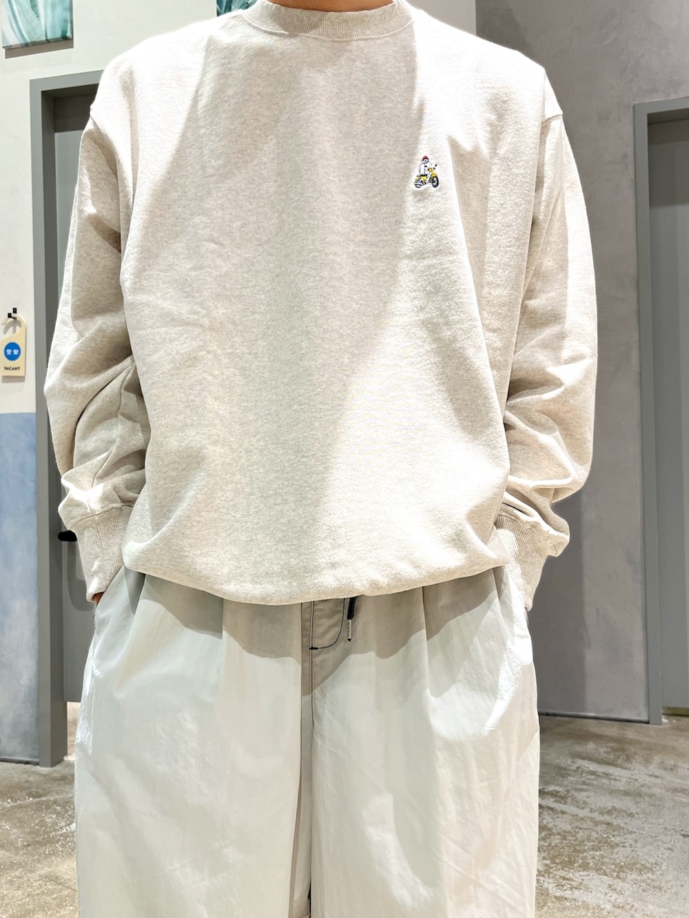 グレー系のスニーカー、グレー系のカーゴパンツ、ホワイト系のスウェットを着用したメンズの冬コーディネートの3枚目の写真