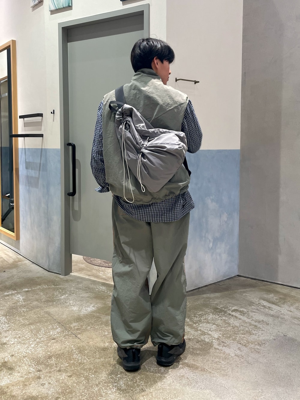 ブラック系のスニーカー、グリーン系のカーゴパンツ、ブルー系のシャツ/ブラウスを着用したメンズの春コーディネートの2枚目の写真