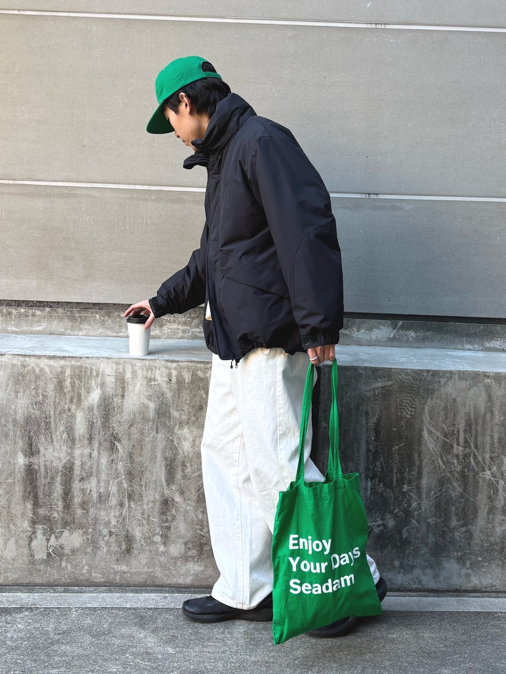 ブラック系のダウンジャケット/コート、ホワイト系のスウェット、グリーン系のキャップを着用したメンズの冬コーディネートの2枚目の写真