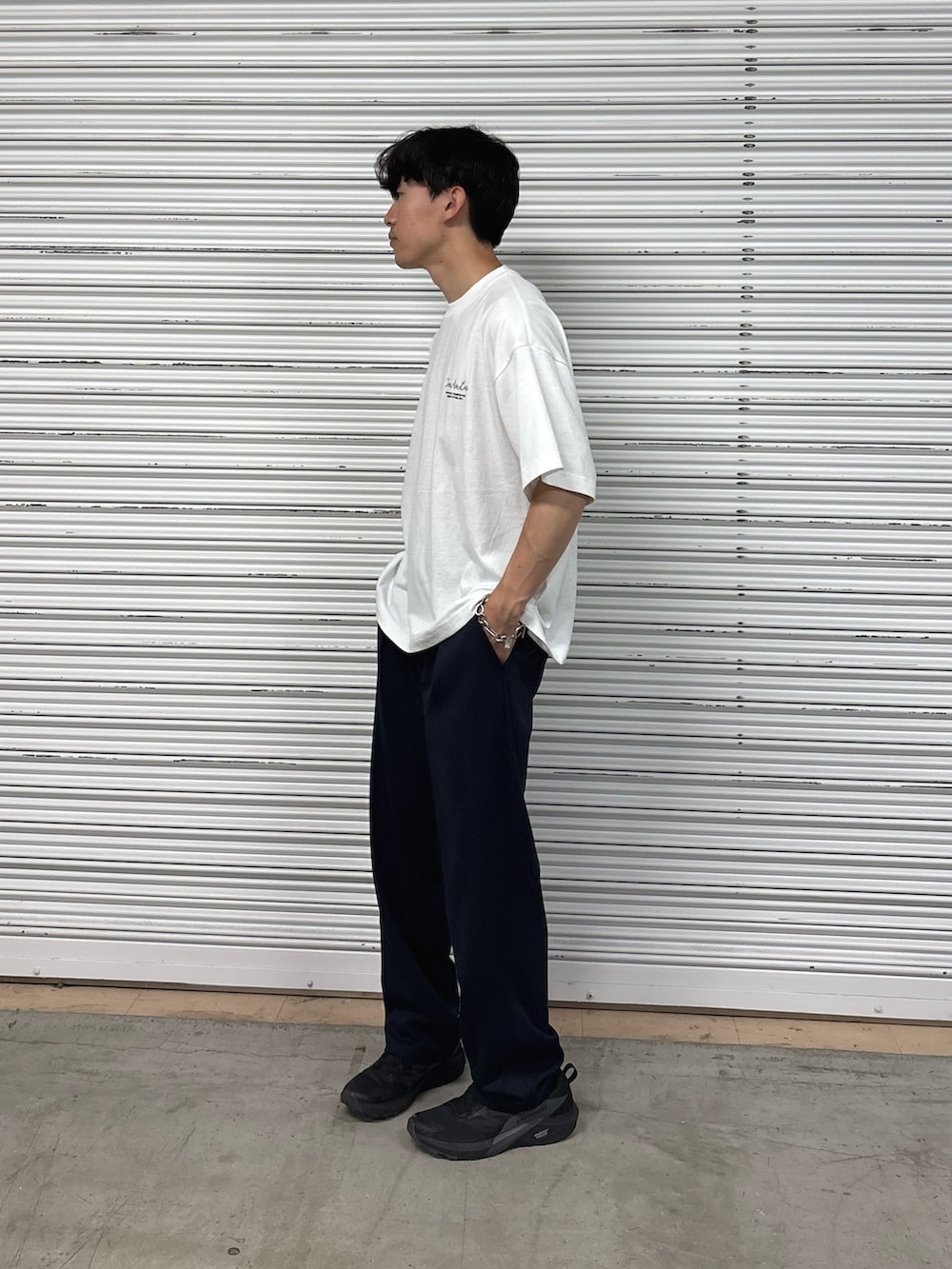 ホワイト系のTシャツ/カットソー、ブルー系のスラックスを着用したメンズの夏コーディネートの2枚目の写真