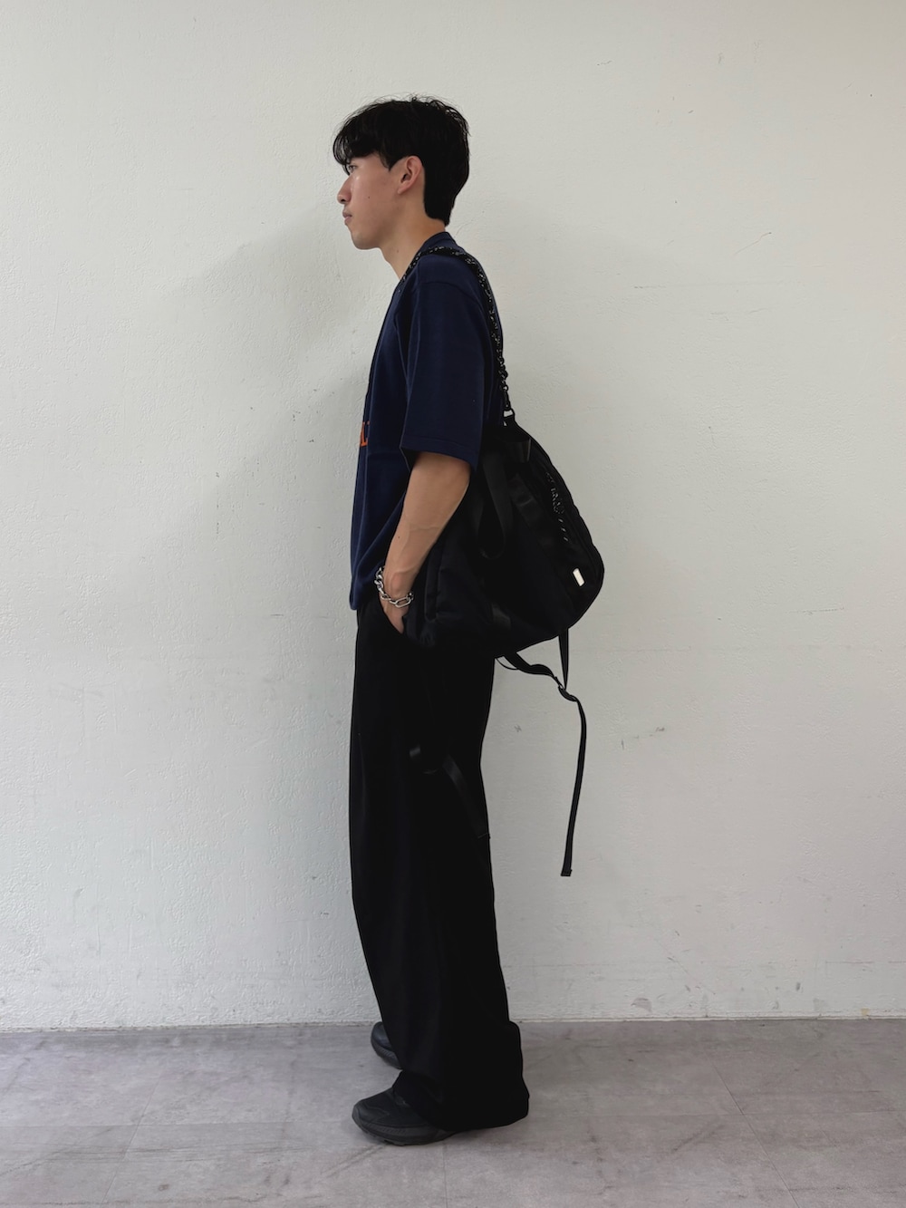 ブルー系のTシャツ/カットソー、ブラック系のトートバッグ、ブラック系のスラックスを着用したメンズの秋コーディネートの2枚目の写真