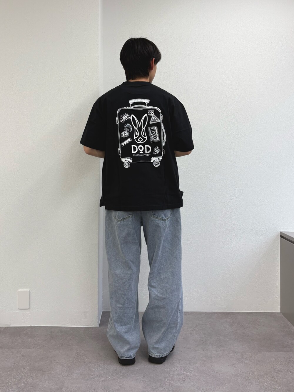 ブラック系のTシャツ/カットソー、ブルー系のデニムパンツ、ブラック系のスニーカーを着用したメンズの春コーディネートの2枚目の写真