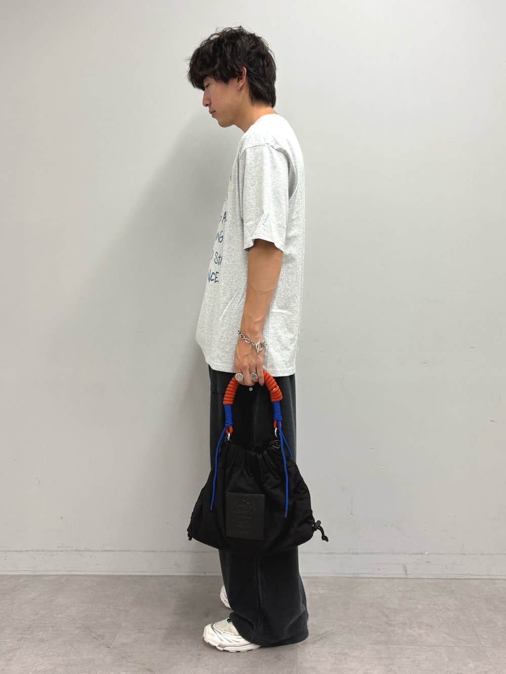 グレー系のTシャツ/カットソー、ブラック系のスウェットパンツ、ブラック系のトートバッグを着用したメンズの夏コーディネートの2枚目の写真