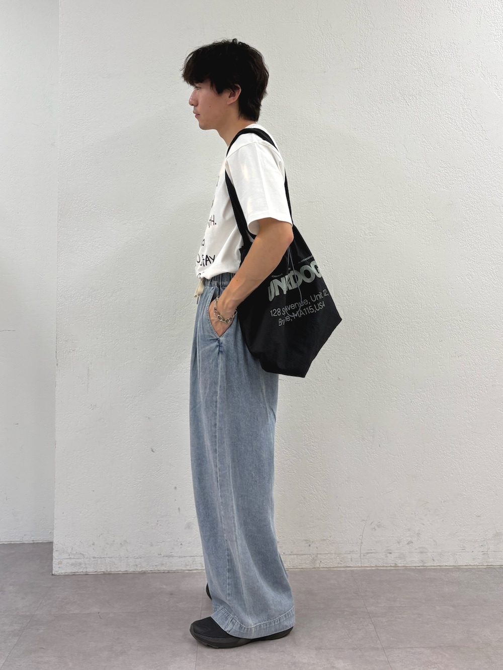 ホワイト系のTシャツ/カットソー、ブラック系のトートバッグ、ブルー系のデニムパンツを着用したメンズの夏コーディネートの2枚目の写真