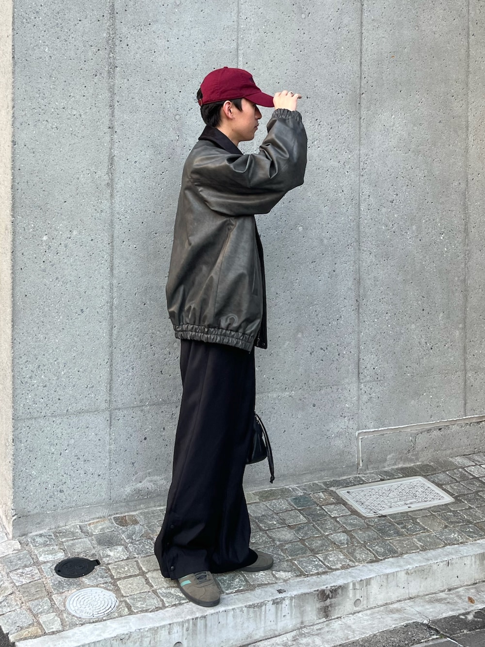 ブラック系のライダースジャケット、グレー系のスウェット、ブラック系のスラックスを着用したメンズの秋コーディネートの2枚目の写真