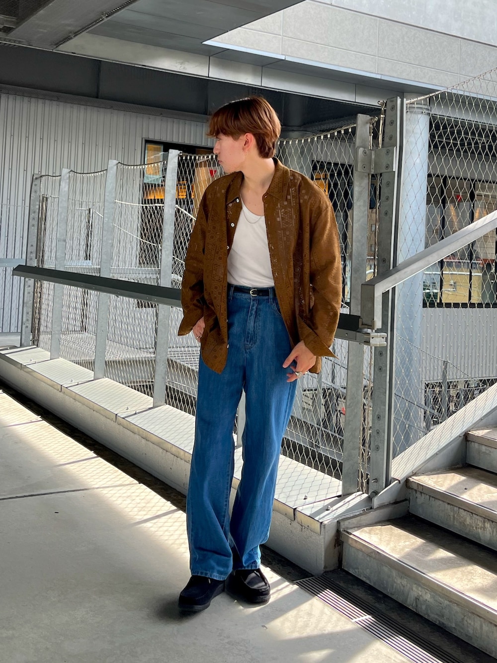 ブラウン系のシャツ/ブラウス、ブラック系のスニーカー、ブルー系のデニムパンツを着用したメンズの夏コーディネートの2枚目の写真