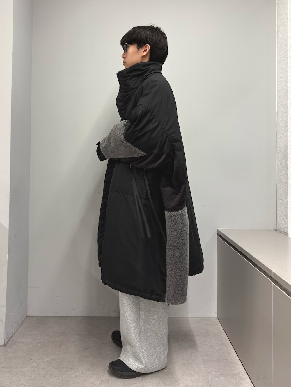 ブラック系のモッズコート、グレー系のその他パンツを着用したメンズの冬コーディネートの2枚目の写真