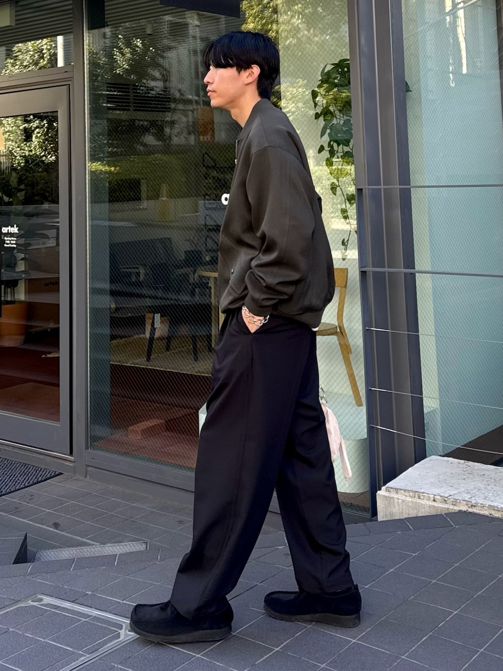 グリーン系のMA-1、ブラック系のスラックス、ブラック系のスニーカーを着用したメンズの冬コーディネートの2枚目の写真