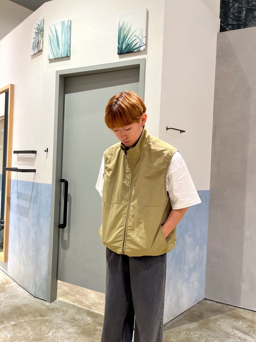 ホワイト系のショルダーバッグ、ホワイト系のTシャツ/カットソー、ベージュ系のベストを着用したメンズの秋コーディネートの2枚目の写真