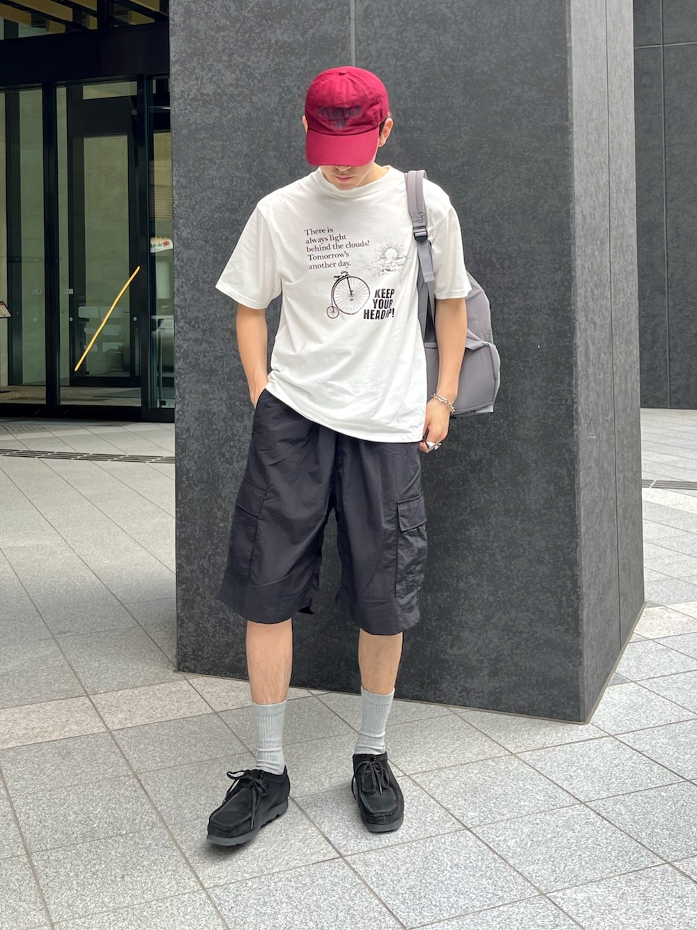 ブラック系のスニーカー、ブラック系のカーゴパンツ、ホワイト系のTシャツ/カットソーを着用したメンズの夏コーディネートの2枚目の写真