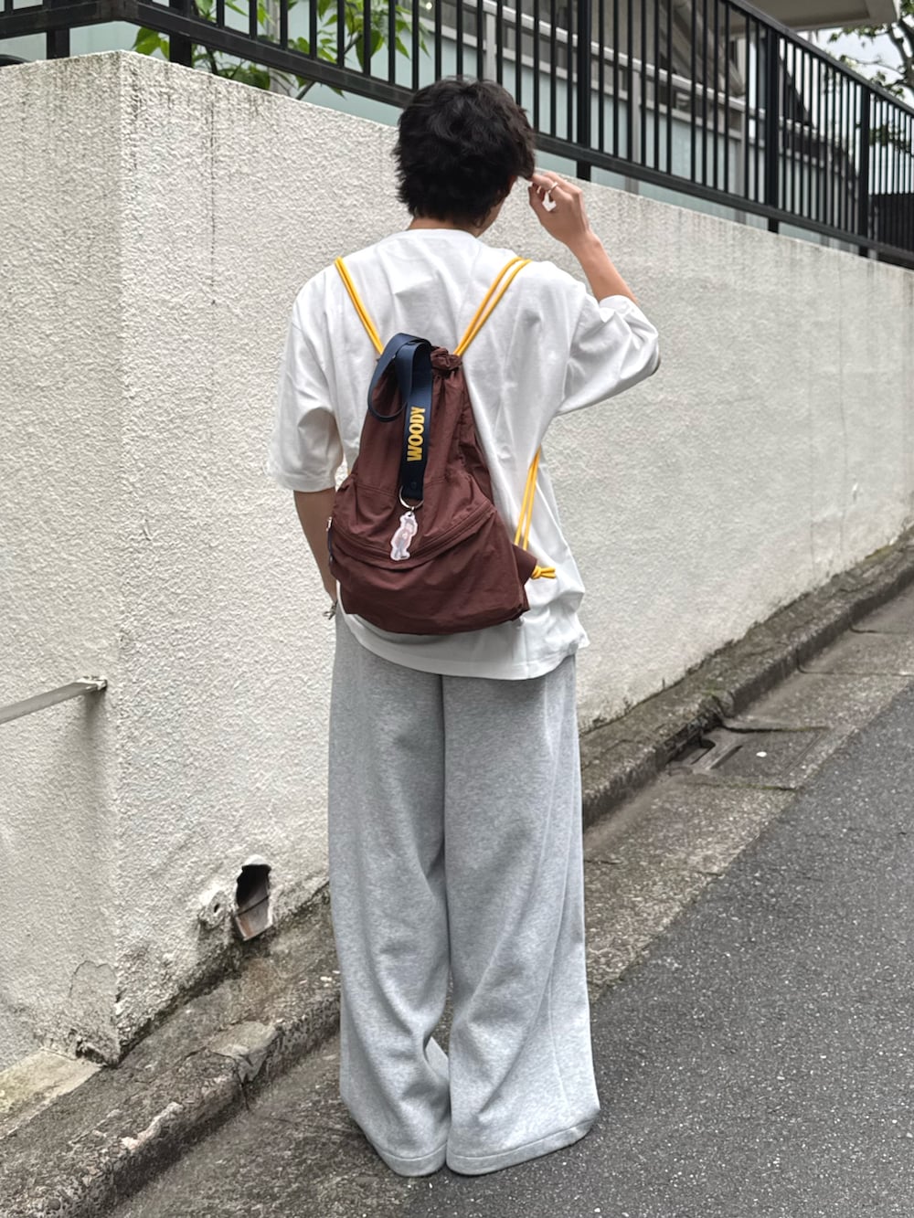 ホワイト系のTシャツ/カットソー、ブラウン系のバックパック/リュックを着用したメンズの春コーディネートの2枚目の写真