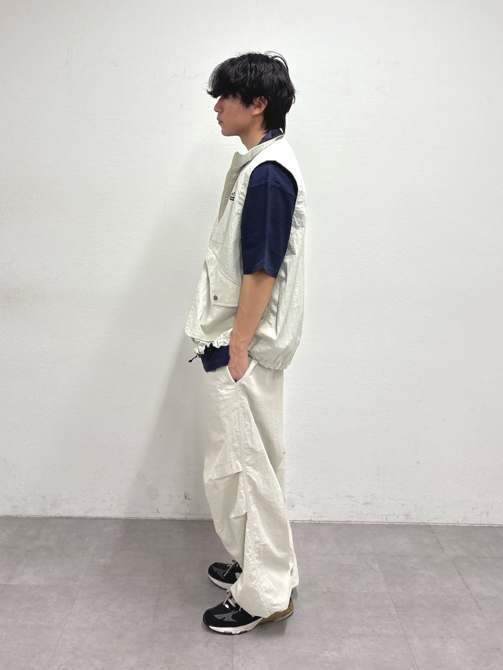 グレー系のベスト、ブルー系のTシャツ/カットソー、グレー系のカーゴパンツを着用したメンズの冬コーディネートの2枚目の写真