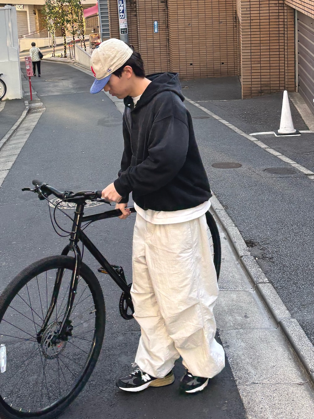 ブラック系のパーカー、グレー系のカーゴパンツを着用したメンズの冬コーディネートの2枚目の写真