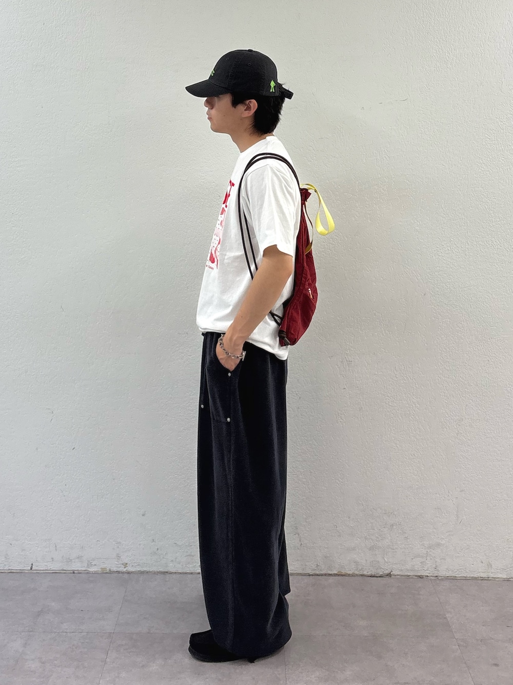 ブラック系のスウェットパンツ、ホワイト系のTシャツ/カットソー、レッド系のバックパック/リュックを着用したメンズの春コーディネートの2枚目の写真
