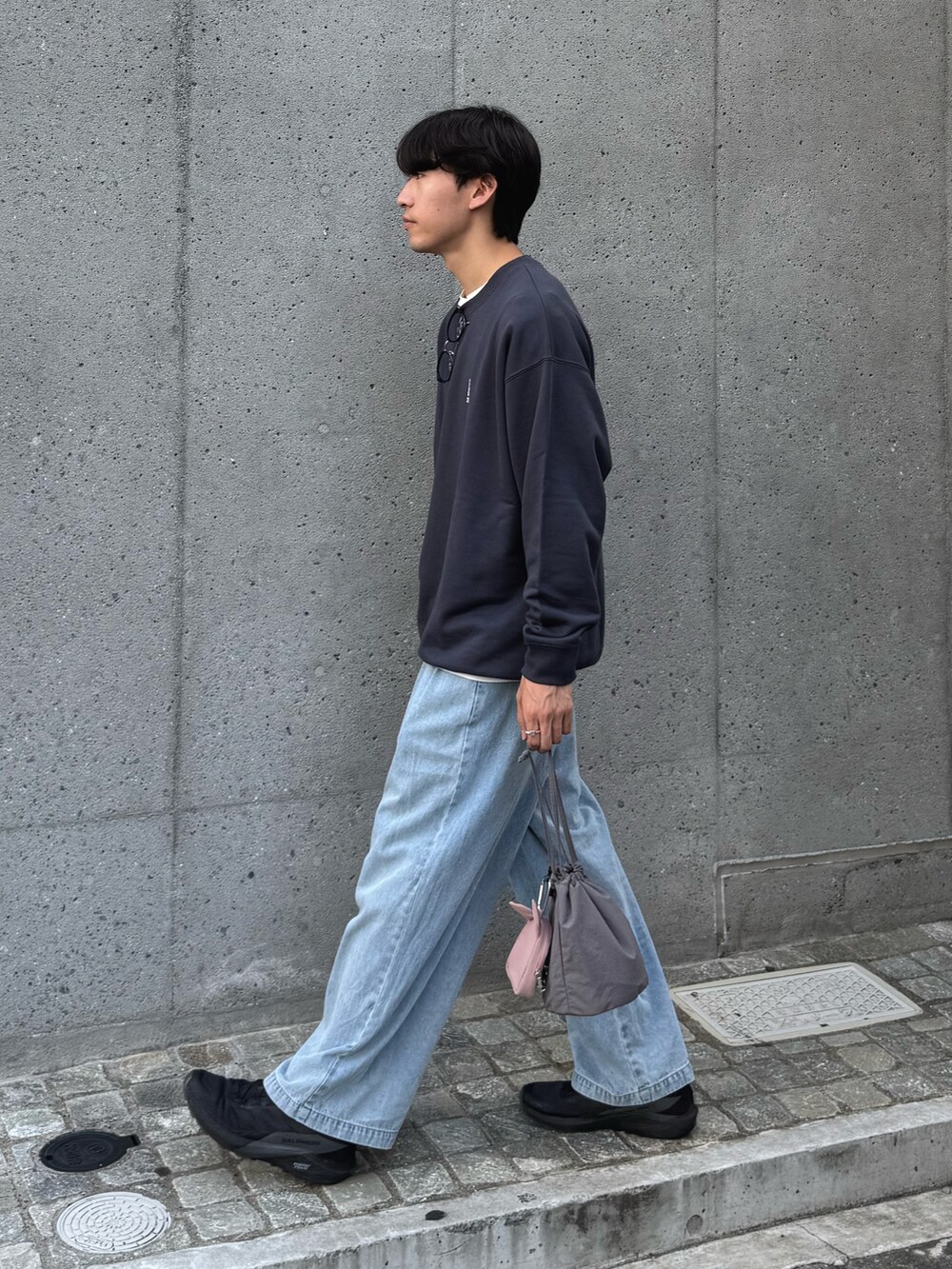 グレー系のスウェット、ブルー系のデニムパンツ、グレー系のトートバッグを着用したメンズの秋コーディネートの2枚目の写真