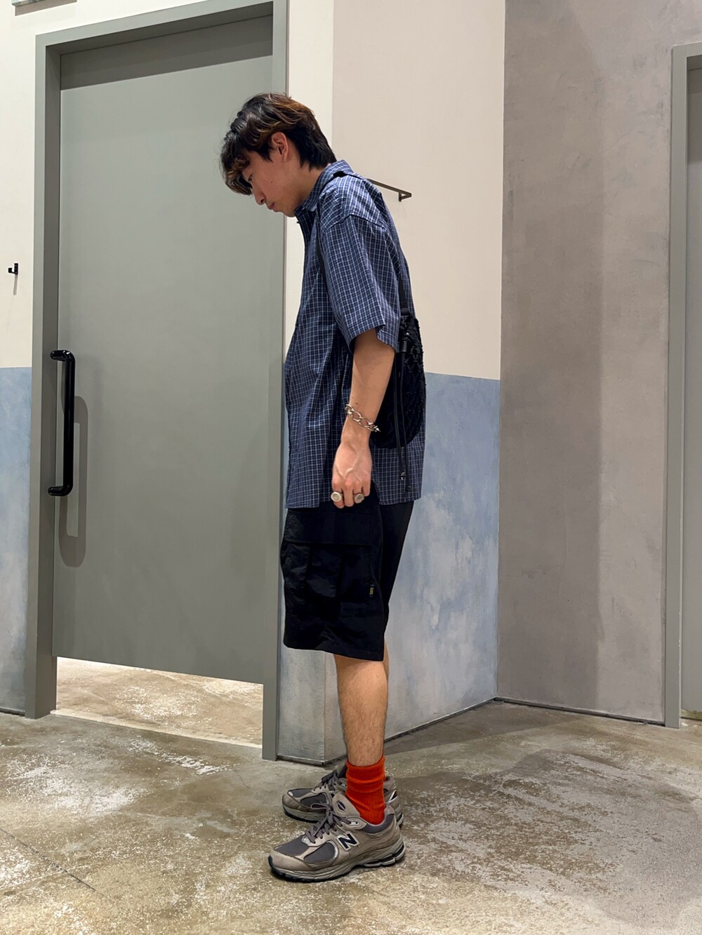 ブラック系のカーゴパンツ、ブルー系のシャツ/ブラウス、ホワイト系のTシャツ/カットソーを着用したメンズの夏コーディネートの2枚目の写真