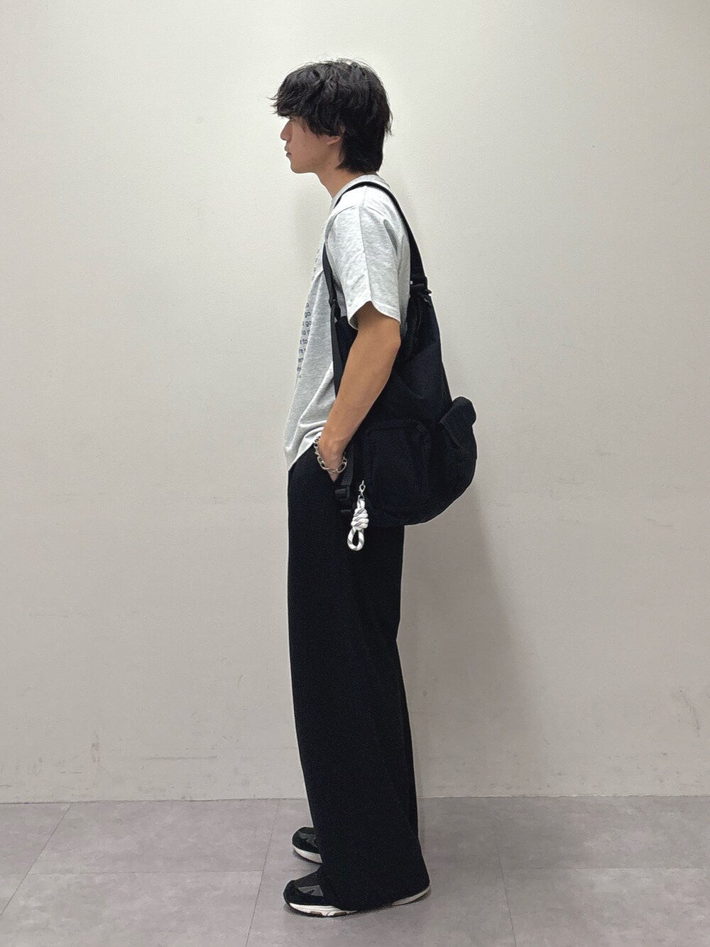 グレー系のTシャツ/カットソー、ブラック系のバックパック/リュック、ブラック系のスラックスを着用したメンズの夏コーディネートの2枚目の写真