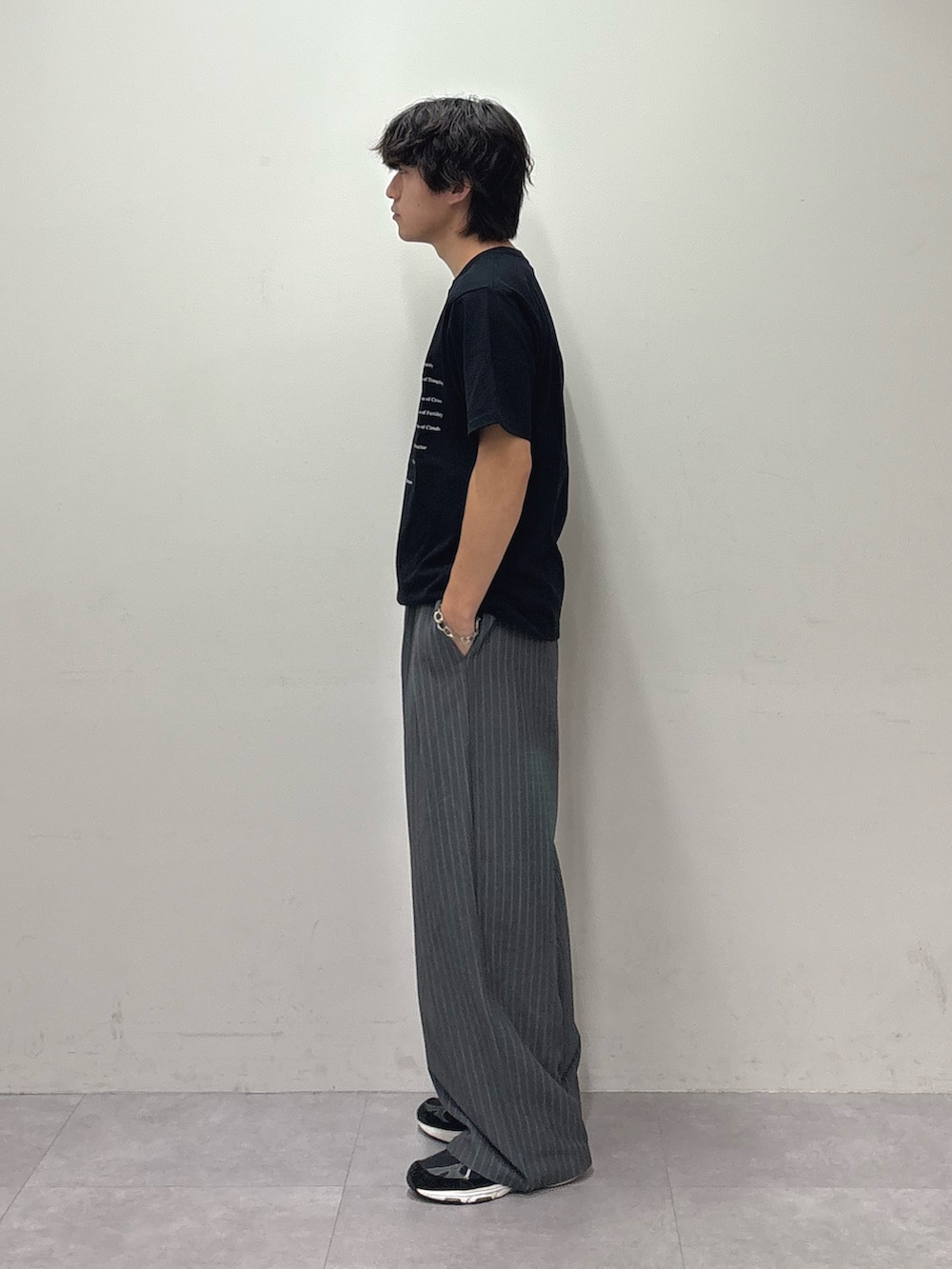ブラック系のTシャツ/カットソー、グレー系のスラックスを着用したメンズの夏コーディネートの2枚目の写真