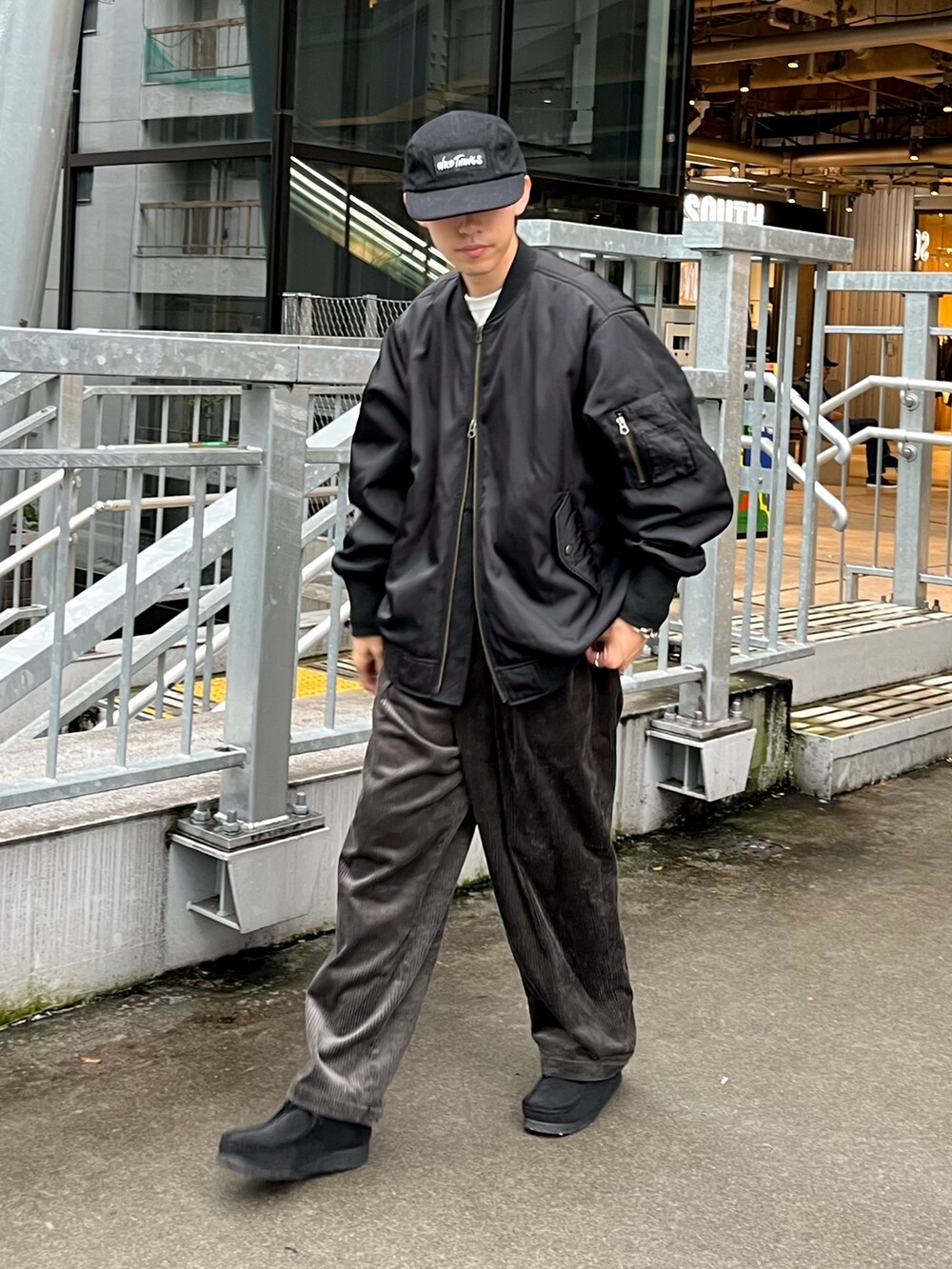 ブラック系のブルゾン、グレー系のその他パンツ、ブラック系のスニーカーを着用したメンズの秋コーディネートの2枚目の写真