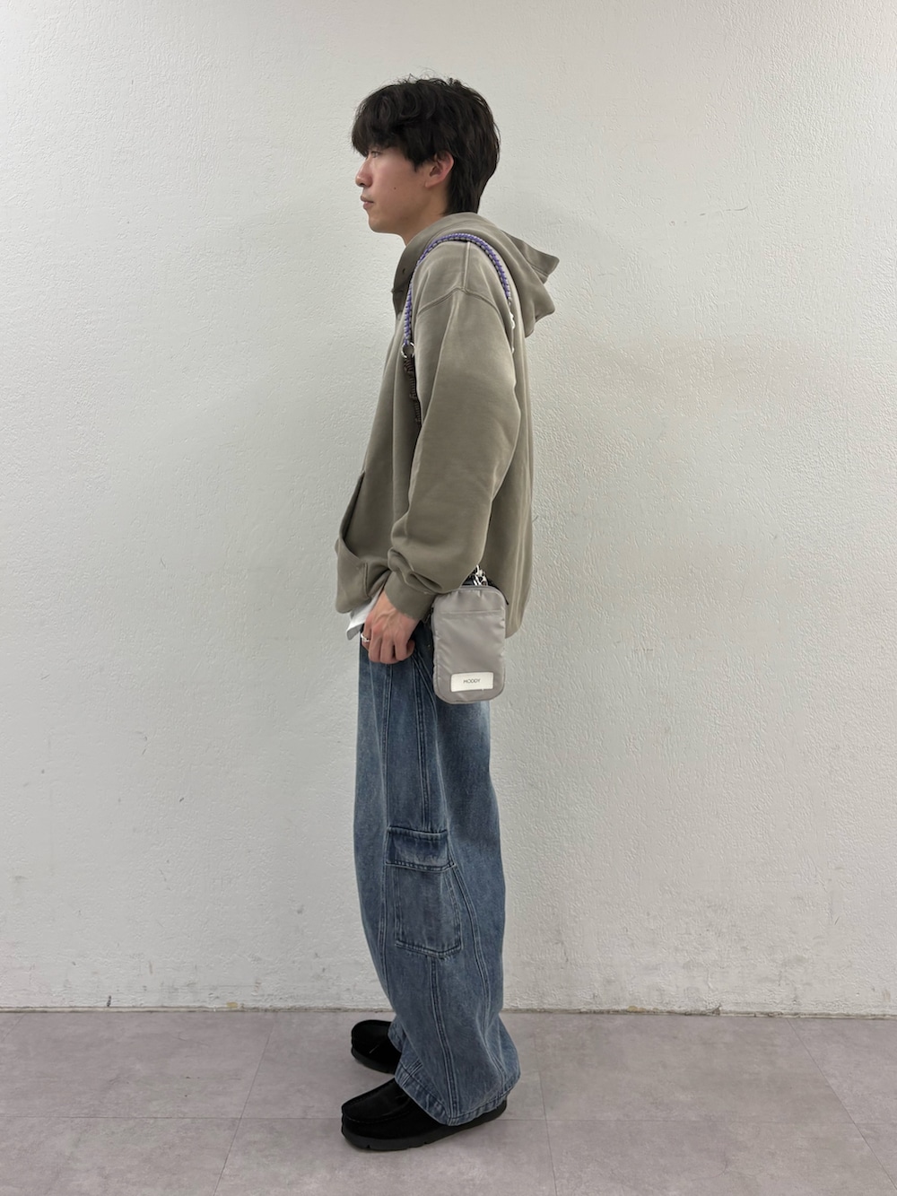 ベージュ系のパーカー、グレー系のショルダーバッグ、ブルー系のカーゴパンツを着用したメンズの春コーディネートの2枚目の写真