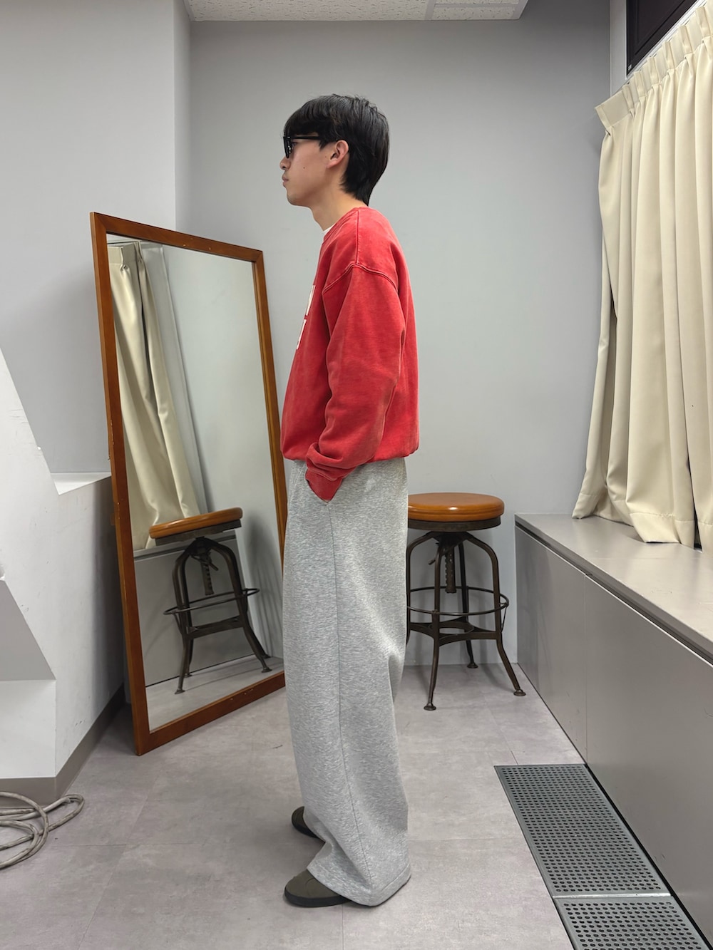 レッド系のスウェット、グレー系のその他パンツを着用したメンズの秋コーディネートの2枚目の写真