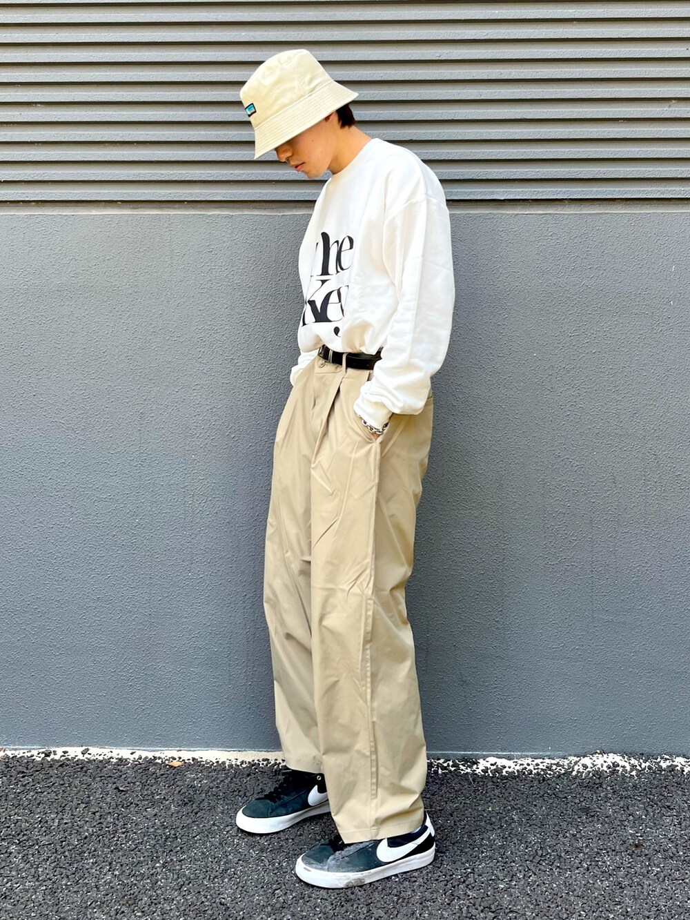 ホワイト系のTシャツ/カットソー、ベージュ系のその他パンツ、ブラック系のスニーカーを着用したメンズの夏コーディネートの2枚目の写真