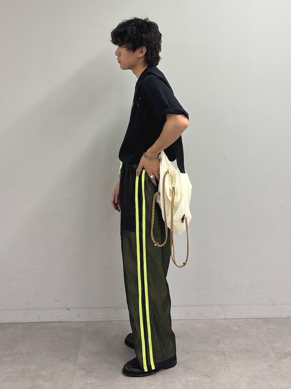 ブラック系のTシャツ/カットソー、ホワイト系のトートバッグ、ブラック系のその他パンツを着用したメンズの春コーディネートの2枚目の写真