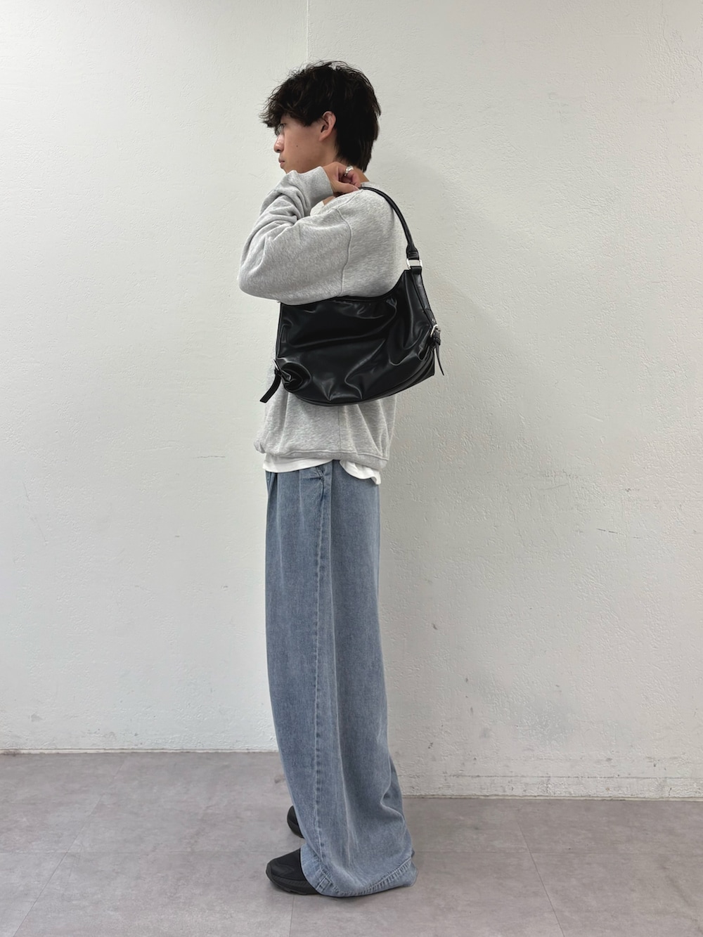 グレー系のスウェット、ブルー系のデニムパンツ、ブラック系のショルダーバッグを着用したメンズの夏コーディネートの2枚目の写真