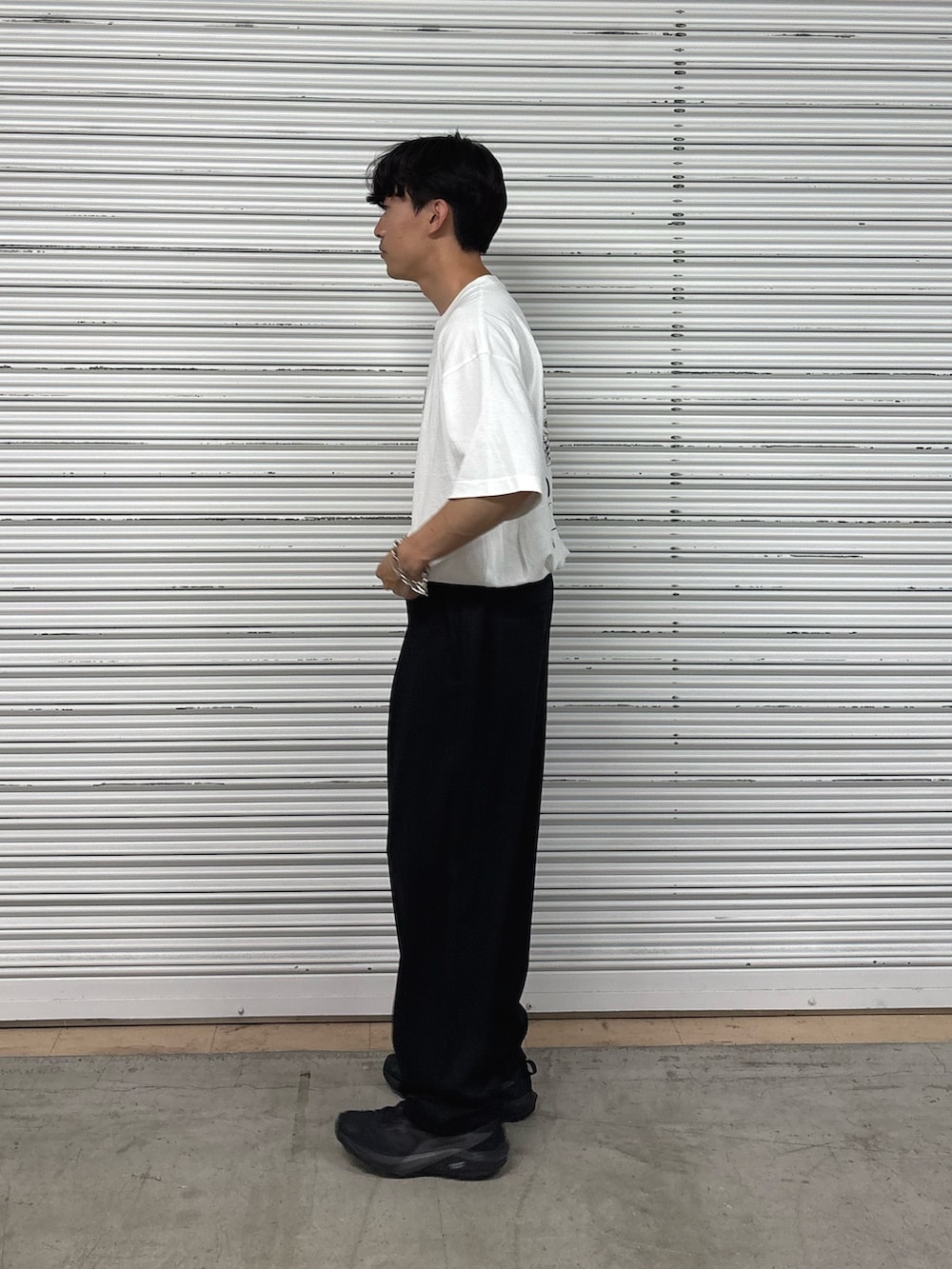 ホワイト系のTシャツ/カットソー、ブラック系のスラックスを着用したメンズの春コーディネートの3枚目の写真