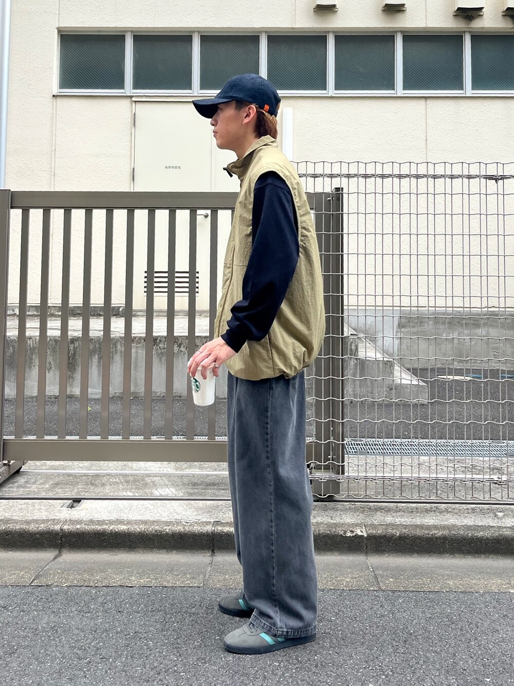 グレー系のスニーカー、グレー系のデニムパンツ、ブラック系のTシャツ/カットソーを着用したメンズの秋コーディネートの2枚目の写真