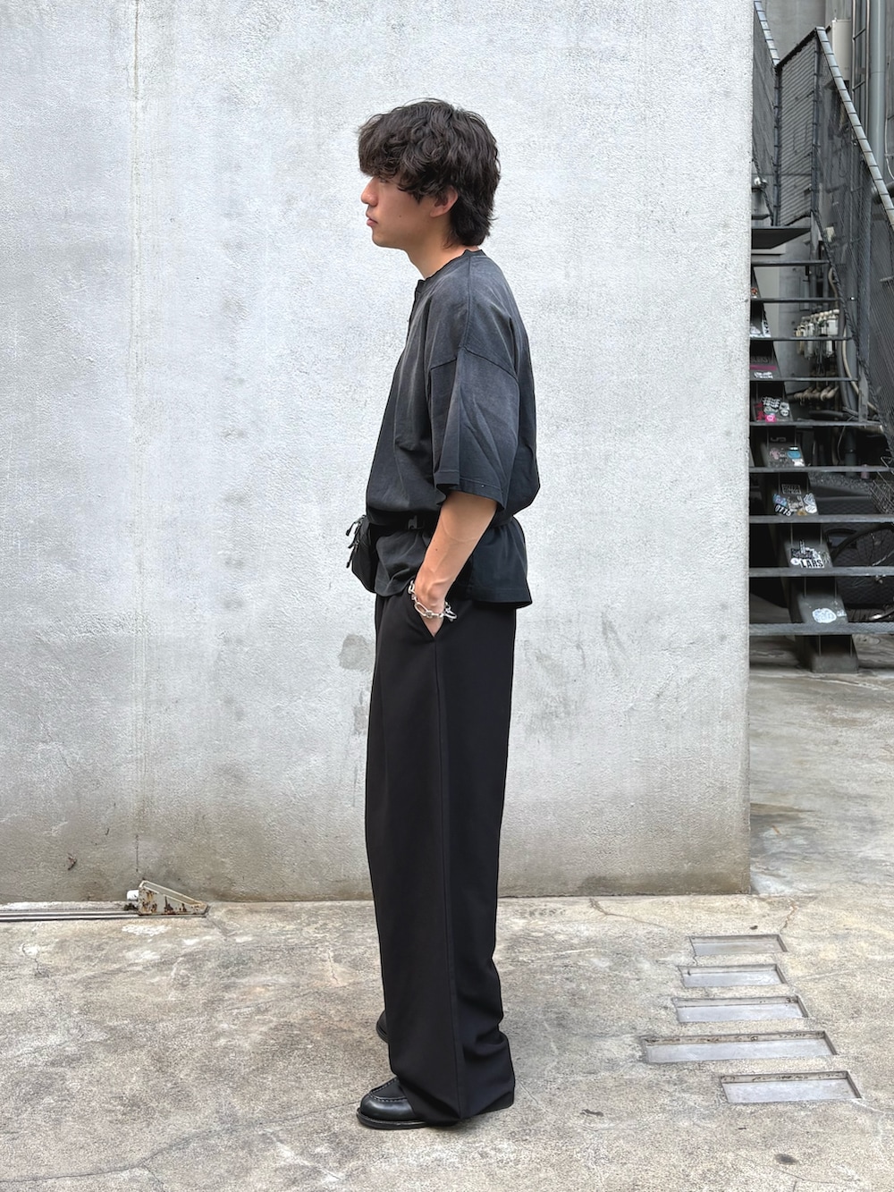 ブラック系のTシャツ/カットソー、ブラック系のスラックスを着用したメンズの春コーディネートの2枚目の写真