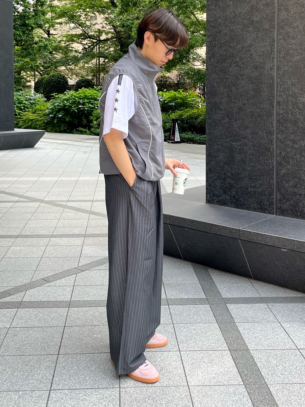 ピンク系のスニーカー、グレー系のスラックス、グレー系のベストを着用したメンズの夏コーディネートの3枚目の写真