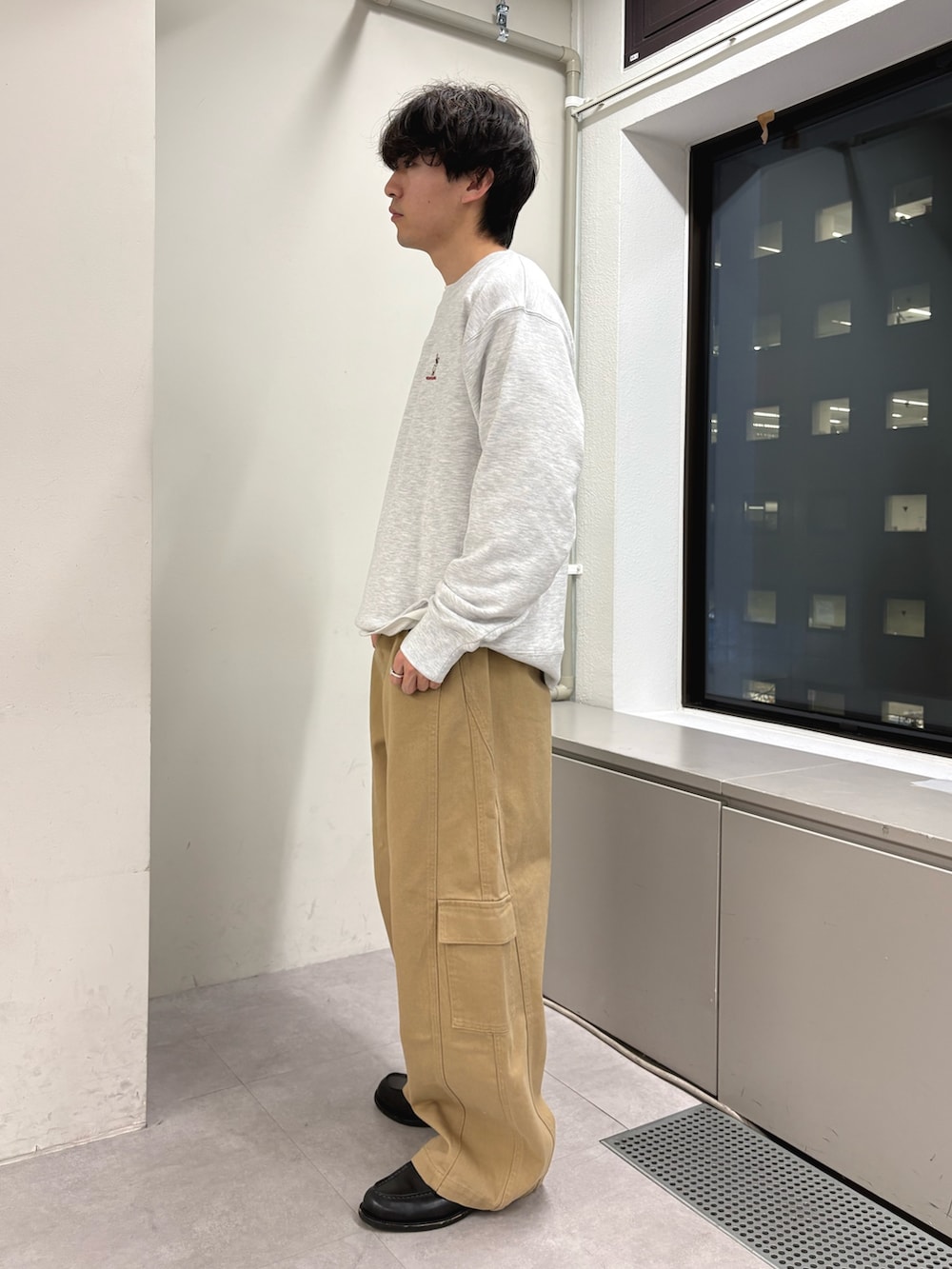 グレー系のスウェット、ベージュ系のカーゴパンツを着用したメンズの冬コーディネートの2枚目の写真