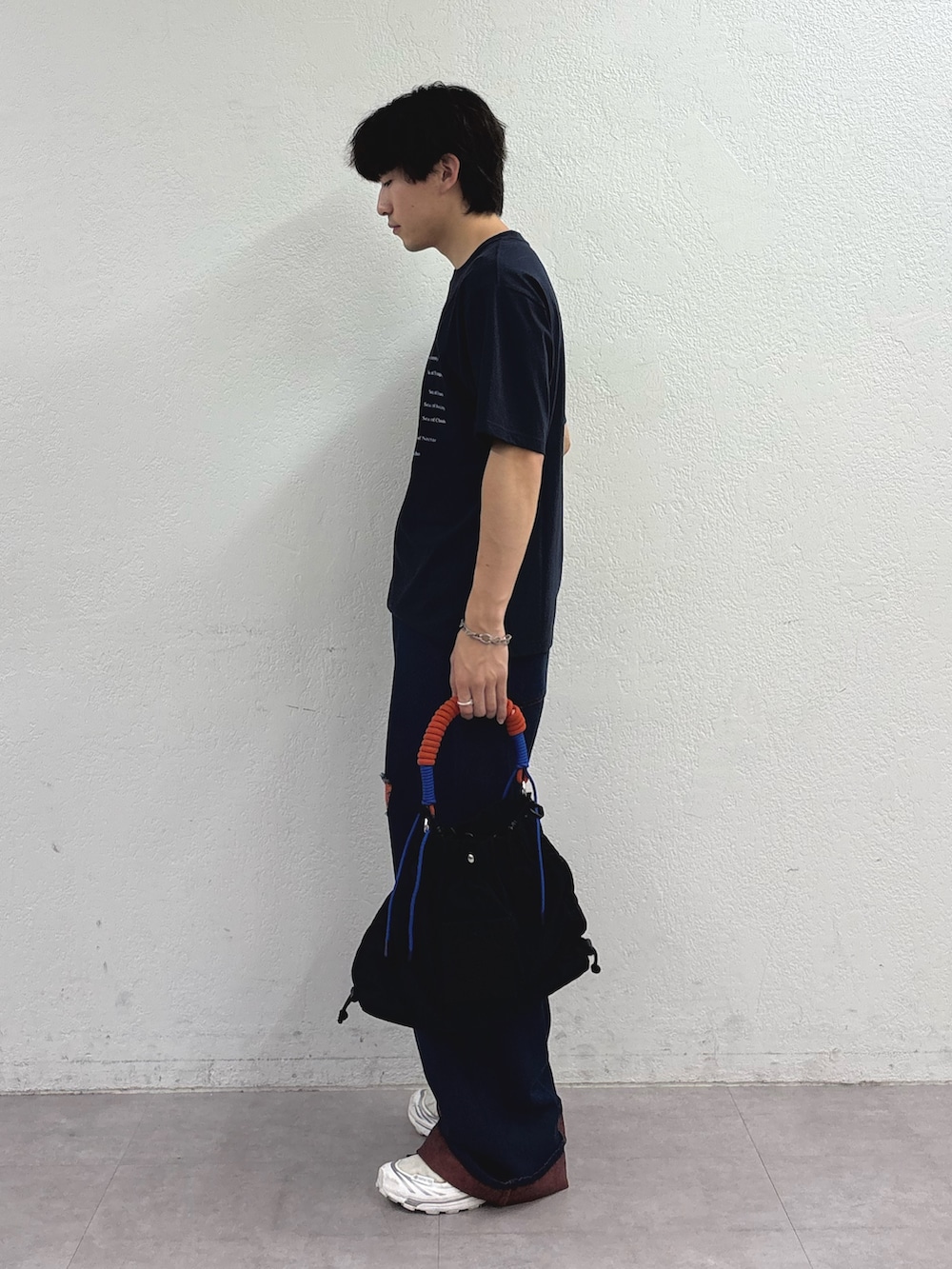 ブルー系のTシャツ/カットソー、オレンジ系のデニムパンツ、ブラック系のトートバッグを着用したメンズの夏コーディネートの2枚目の写真