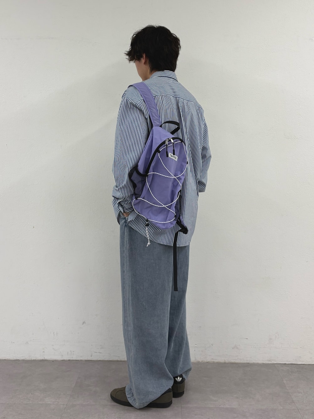 ブルー系のシャツ/ブラウス、パープル系のバックパック/リュック、ブルー系のデニムパンツを着用したメンズの秋コーディネートの2枚目の写真