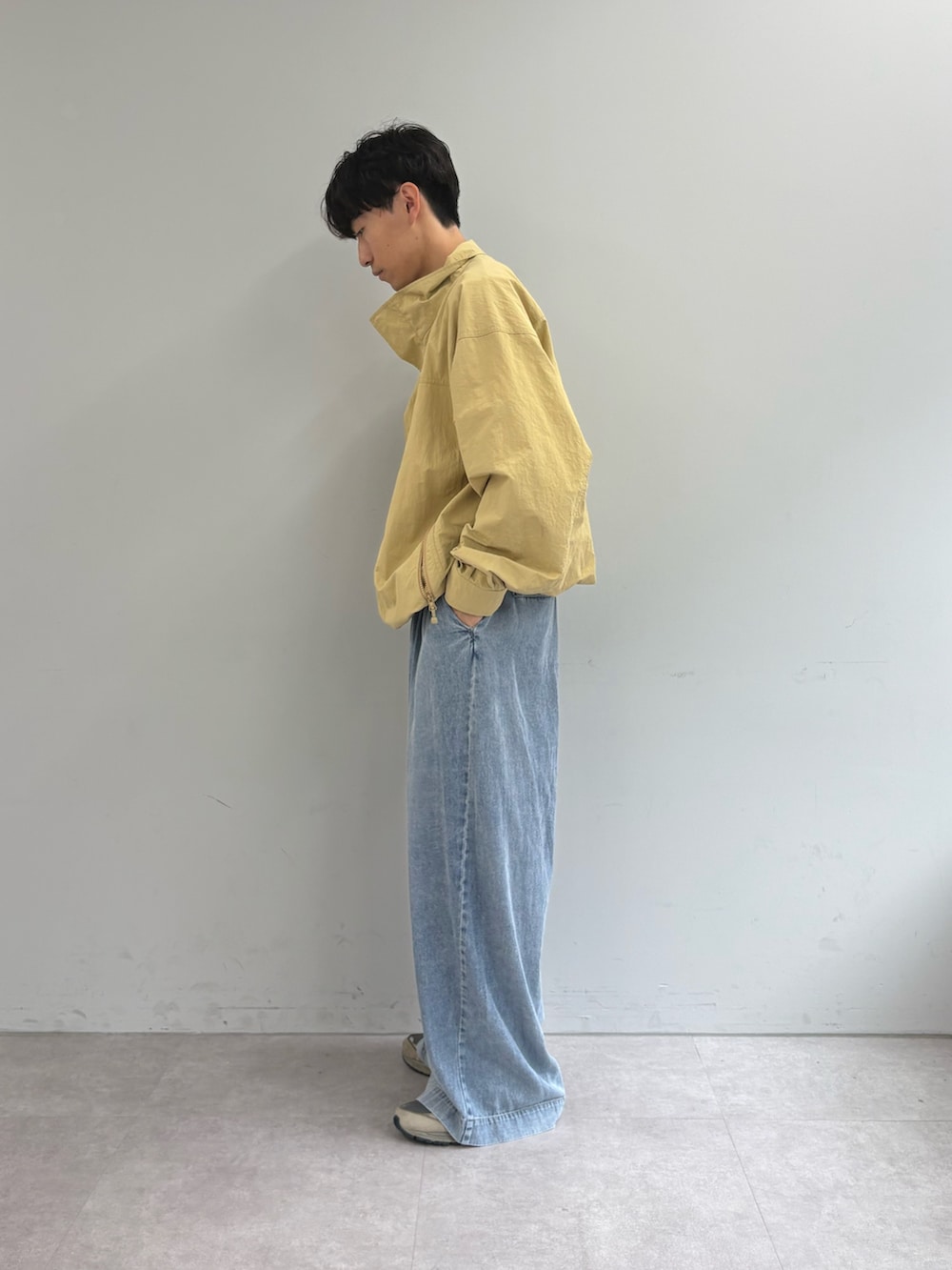 ホワイト系のTシャツ/カットソー、ベージュ系のナイロンジャケット、ブルー系のデニムパンツを着用したメンズの春コーディネートの2枚目の写真