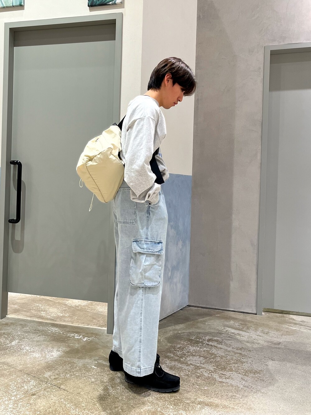 ブラック系のスニーカー、ブルー系のカーゴパンツ、グレー系のTシャツ/カットソーを着用したメンズの春コーディネートの3枚目の写真