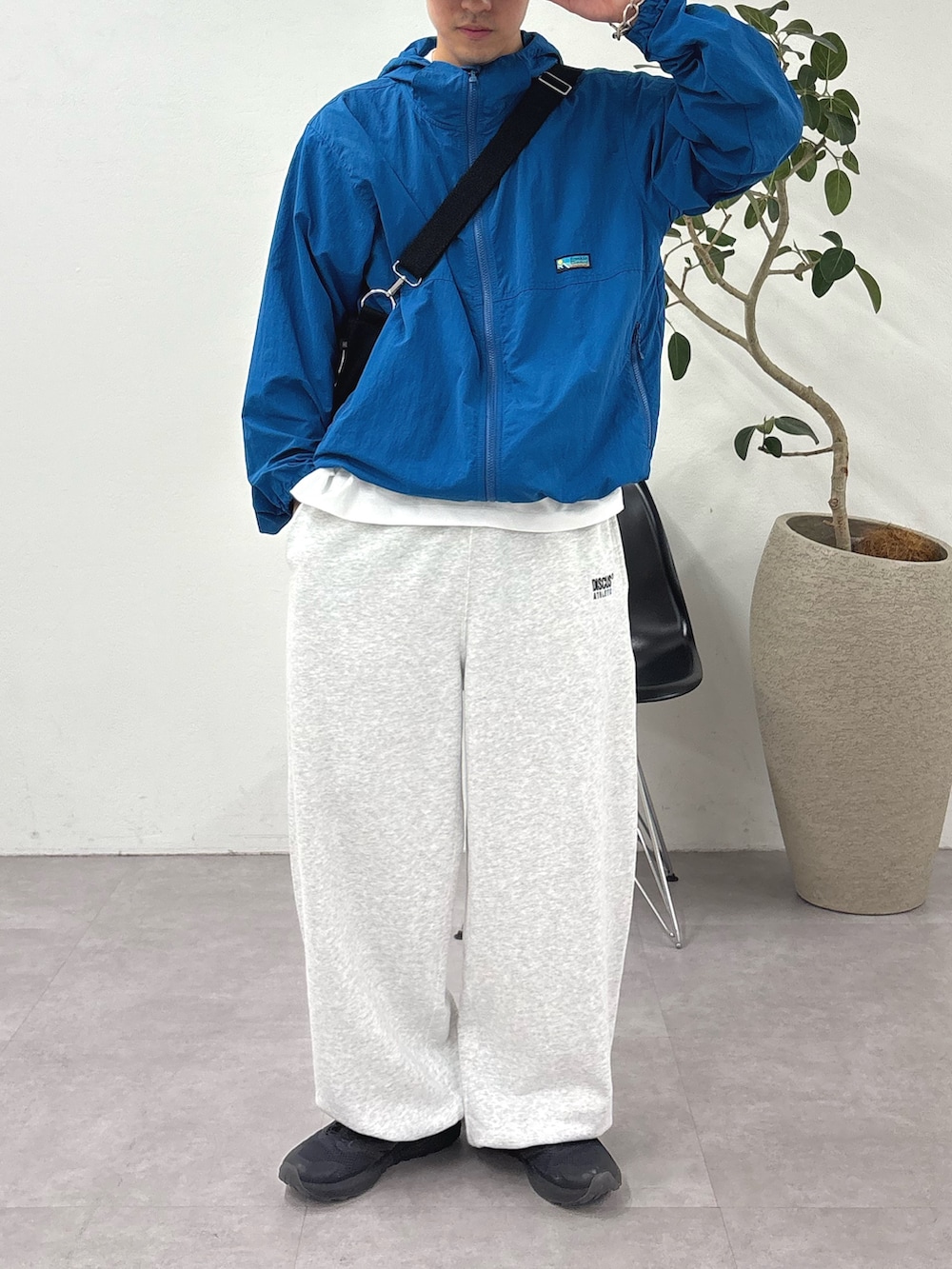 ブルー系のパーカー、ブラック系のショルダーバッグ、グレー系のスウェットパンツを着用したメンズの夏コーディネートの2枚目の写真