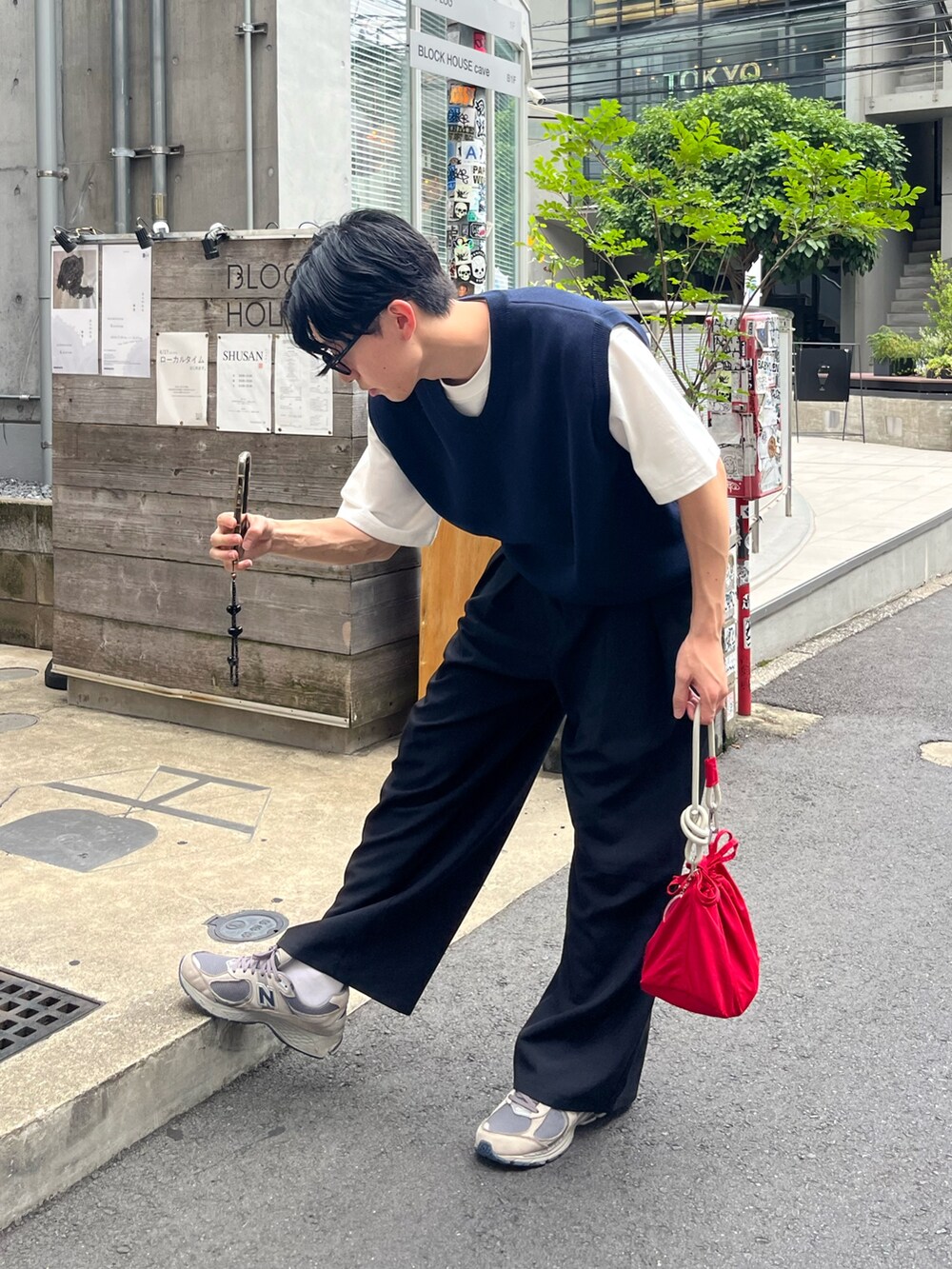 ホワイト系のTシャツ/カットソー、ブルー系のベスト、ブラック系のスラックスを着用したメンズの夏コーディネートの3枚目の写真